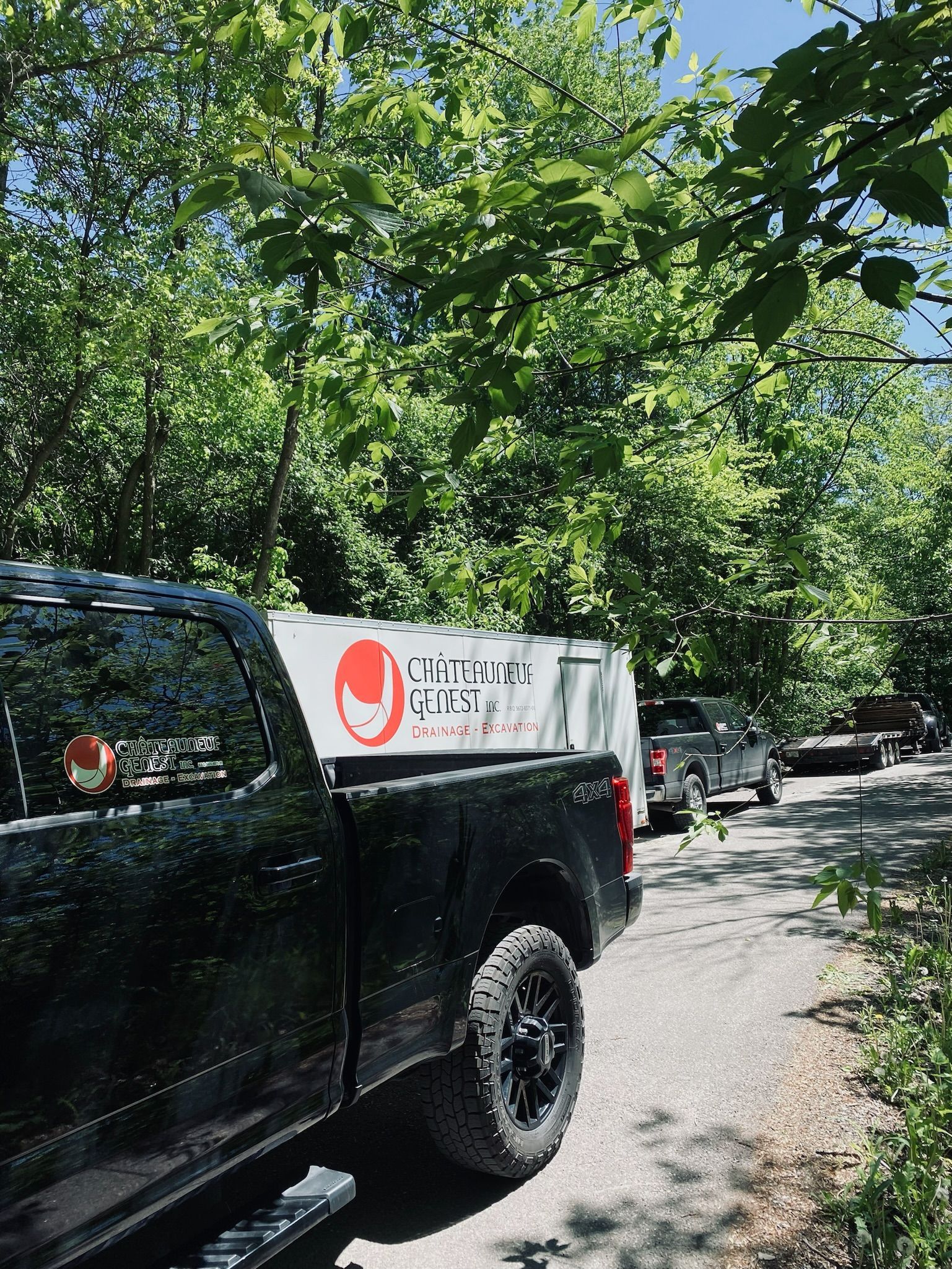 Un camion noir est garé sur le bord d'une route.