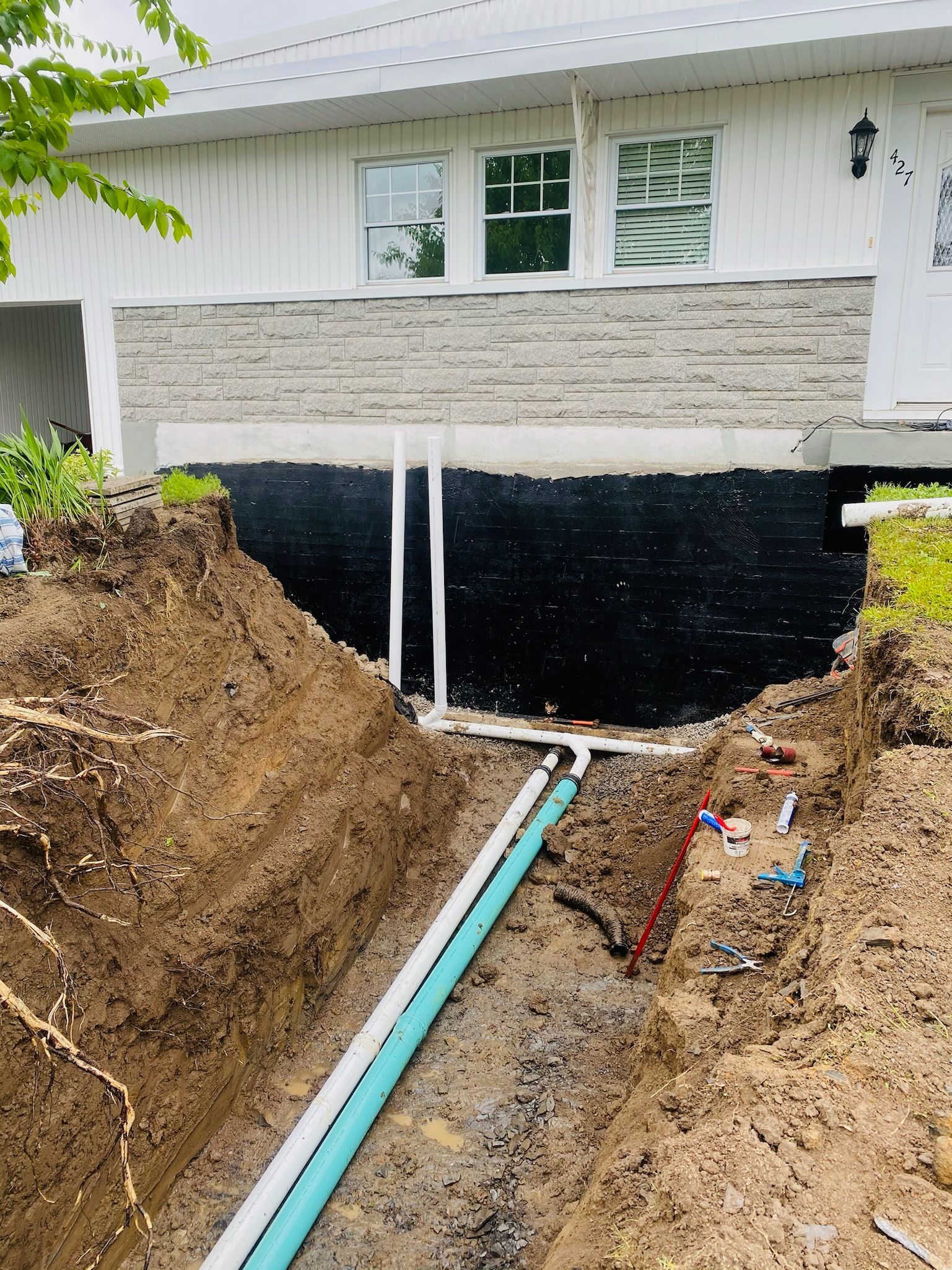Un gros tas de terre se trouve devant une maison blanche.