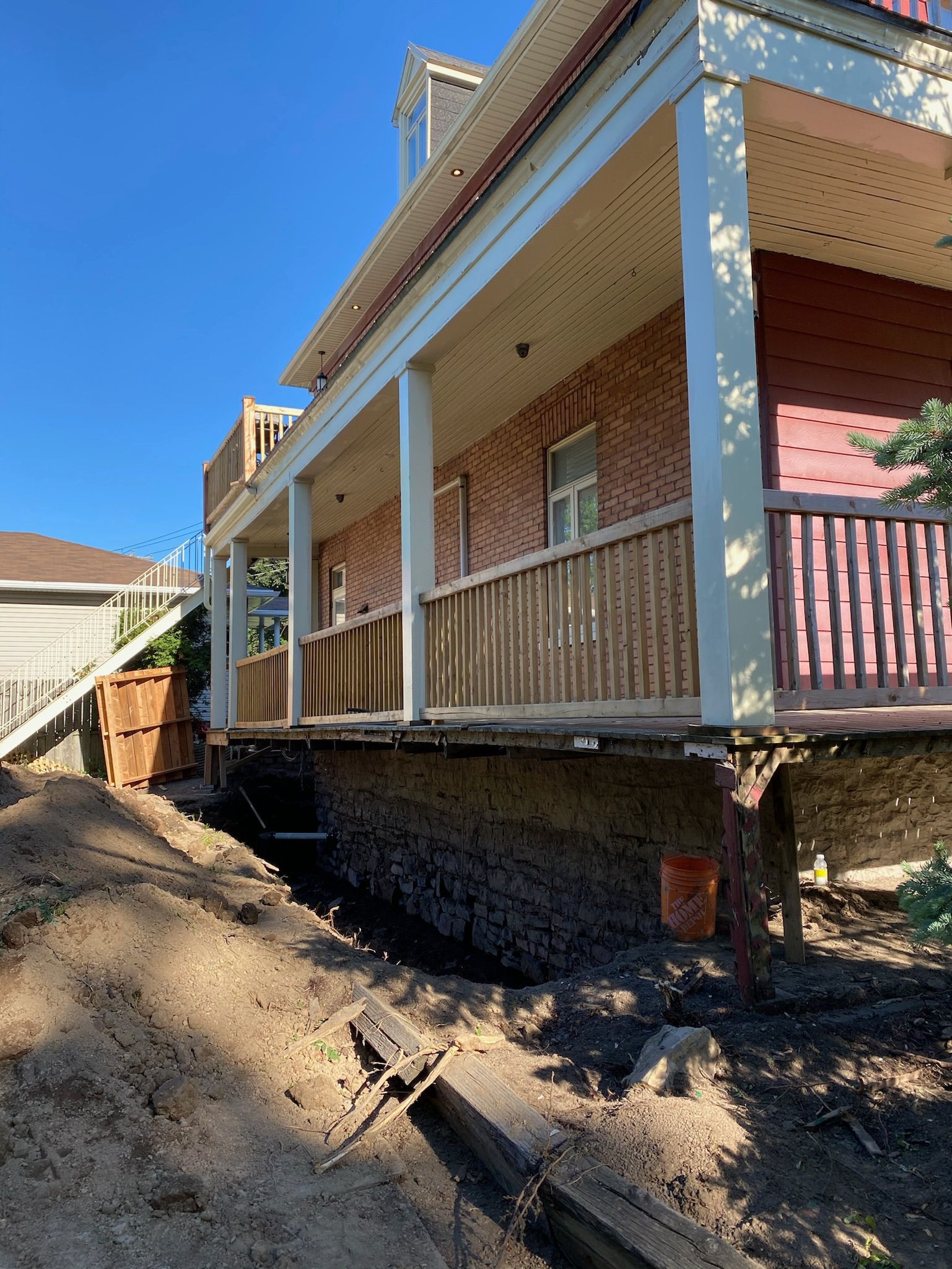 Une maison en brique avec un grand porche et des escaliers