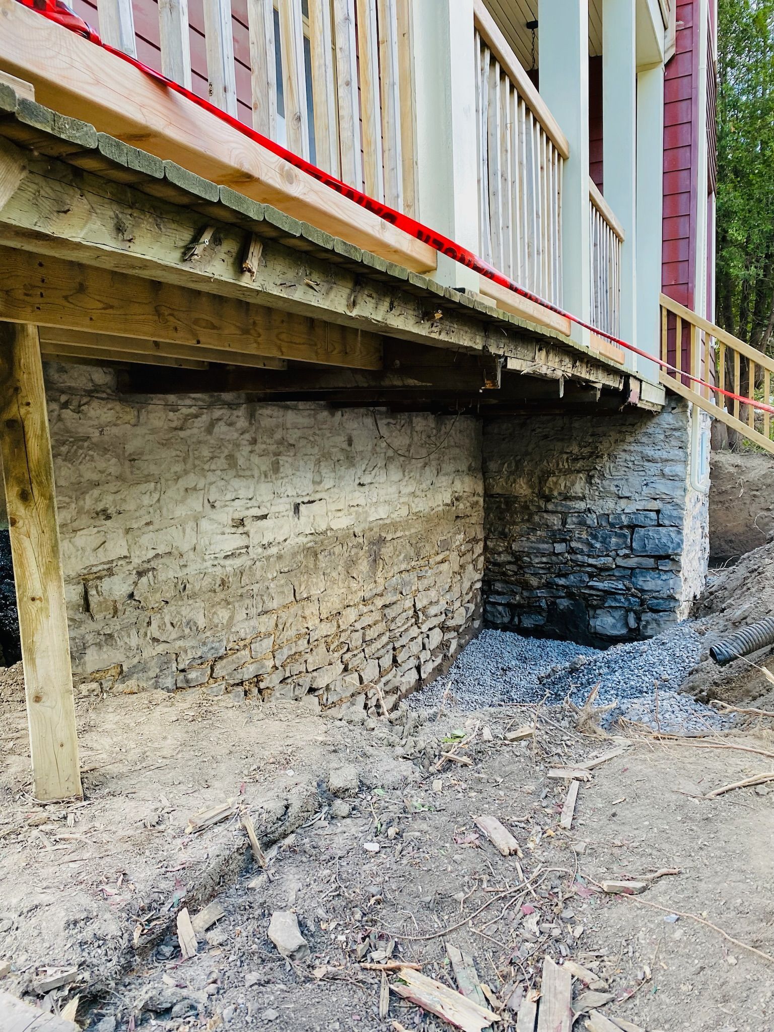Une maison en construction avec un mur en briques et une terrasse en bois.