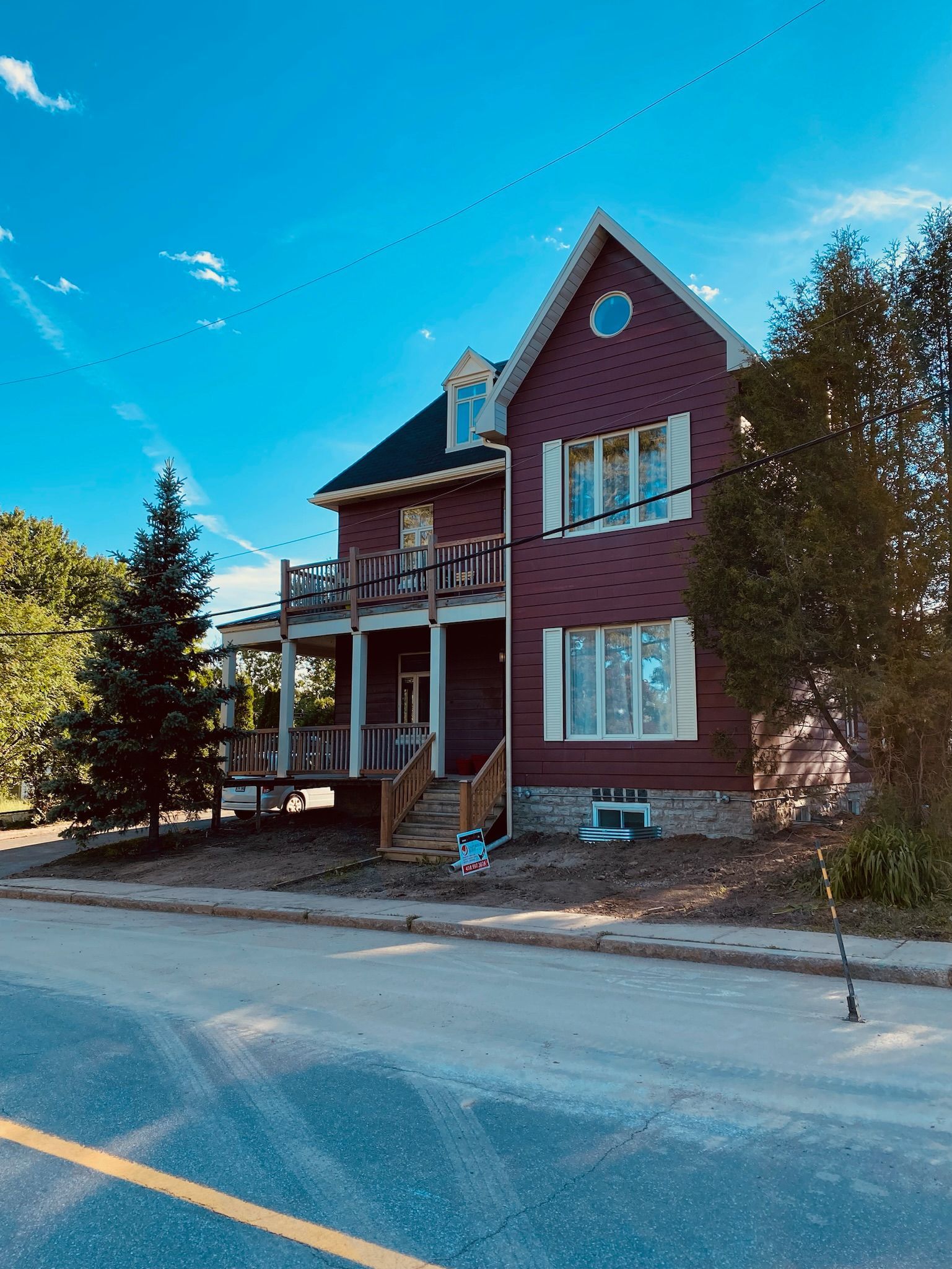Une grande maison en briques rouges se trouve au bord de la route.