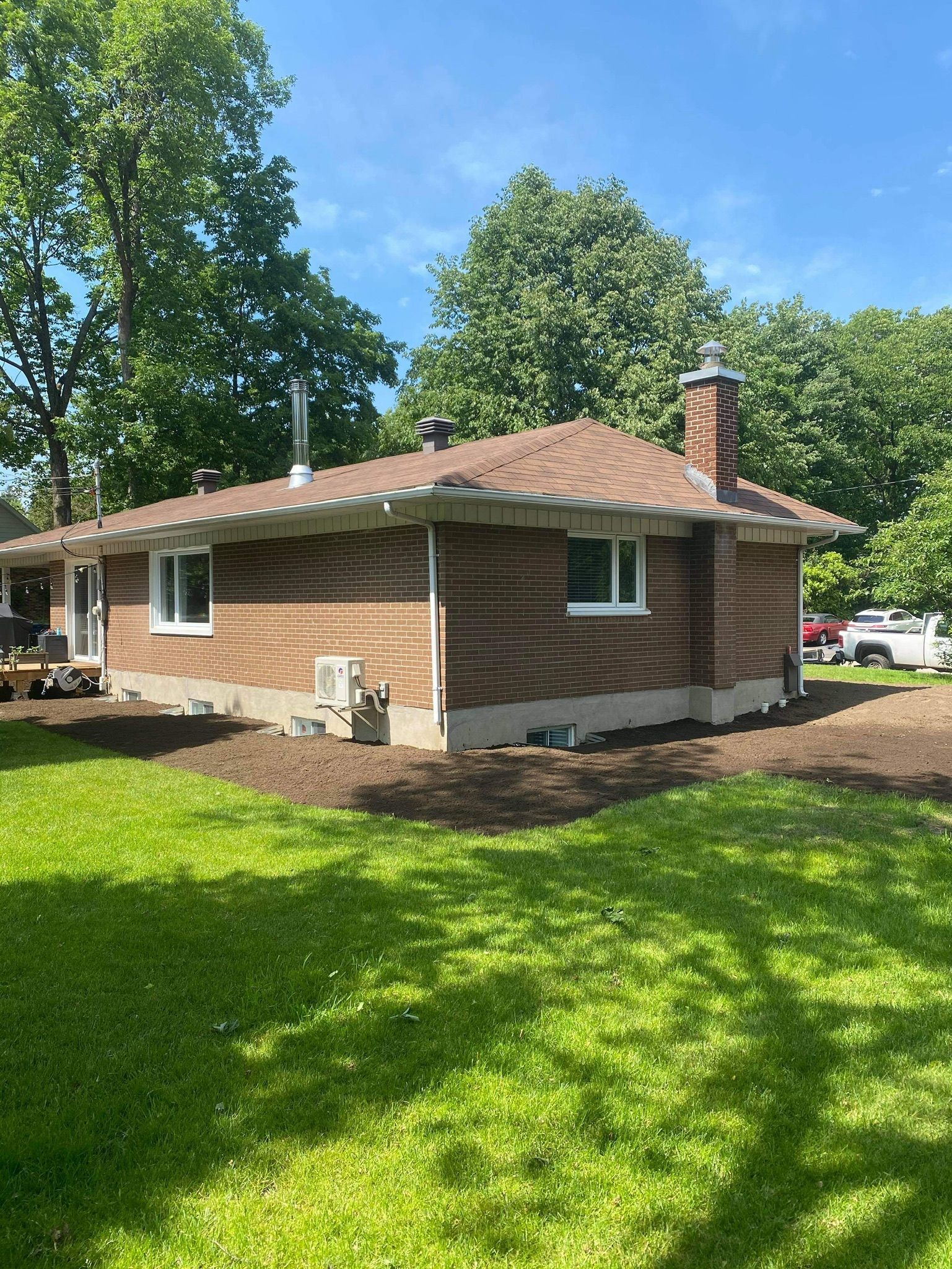 Une maison en briques est assise sur une pelouse verte luxuriante.