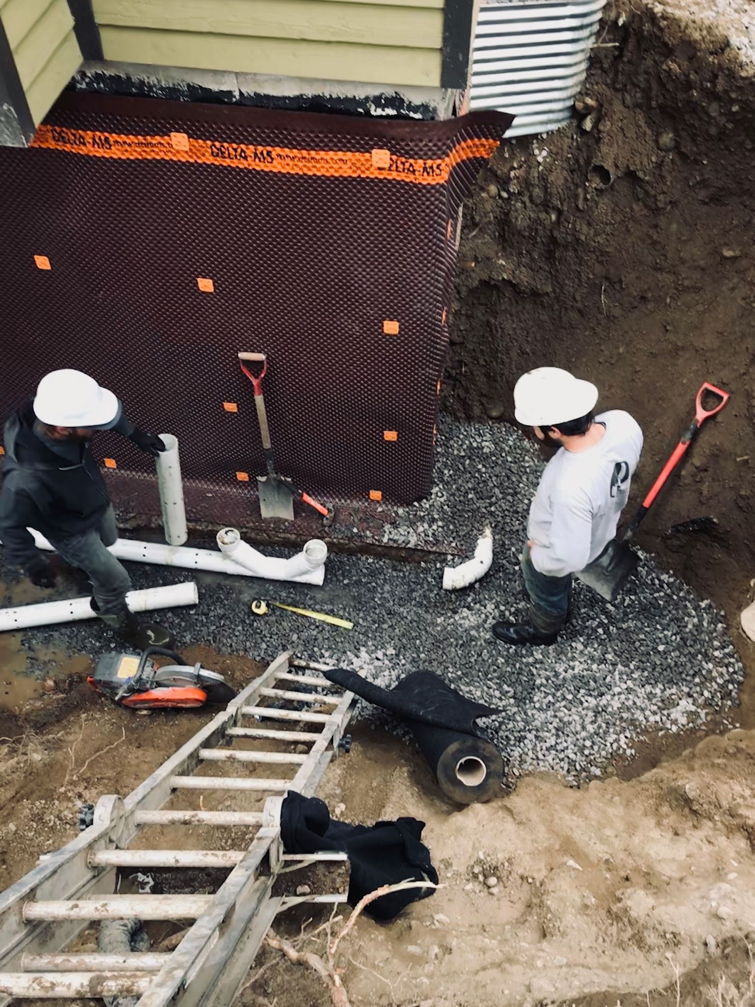 Un groupe d'ouvriers du bâtiment travaille dans un trou dans le sol.