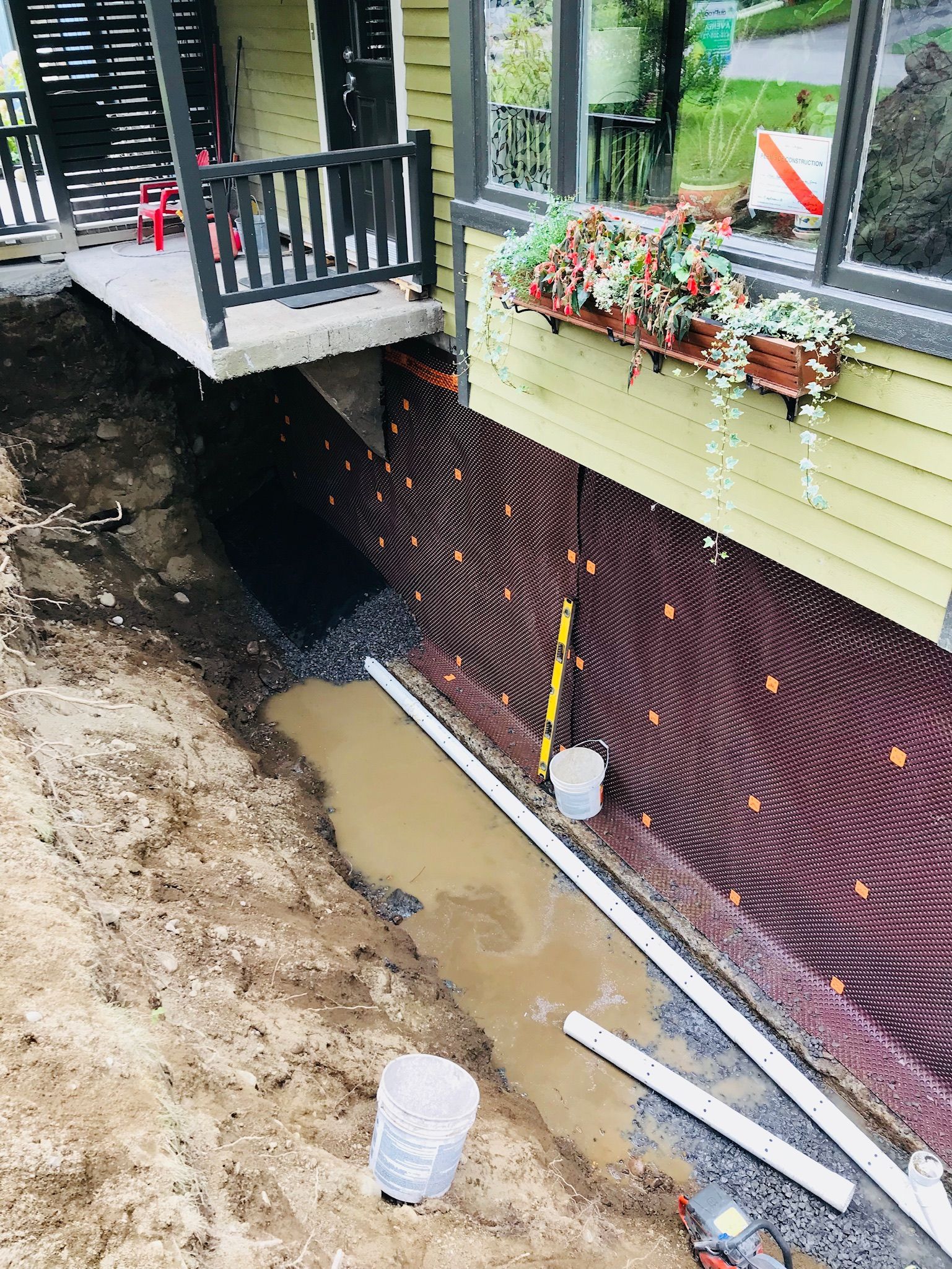 Un système de drainage est en cours d'installation sur le côté d'une maison.