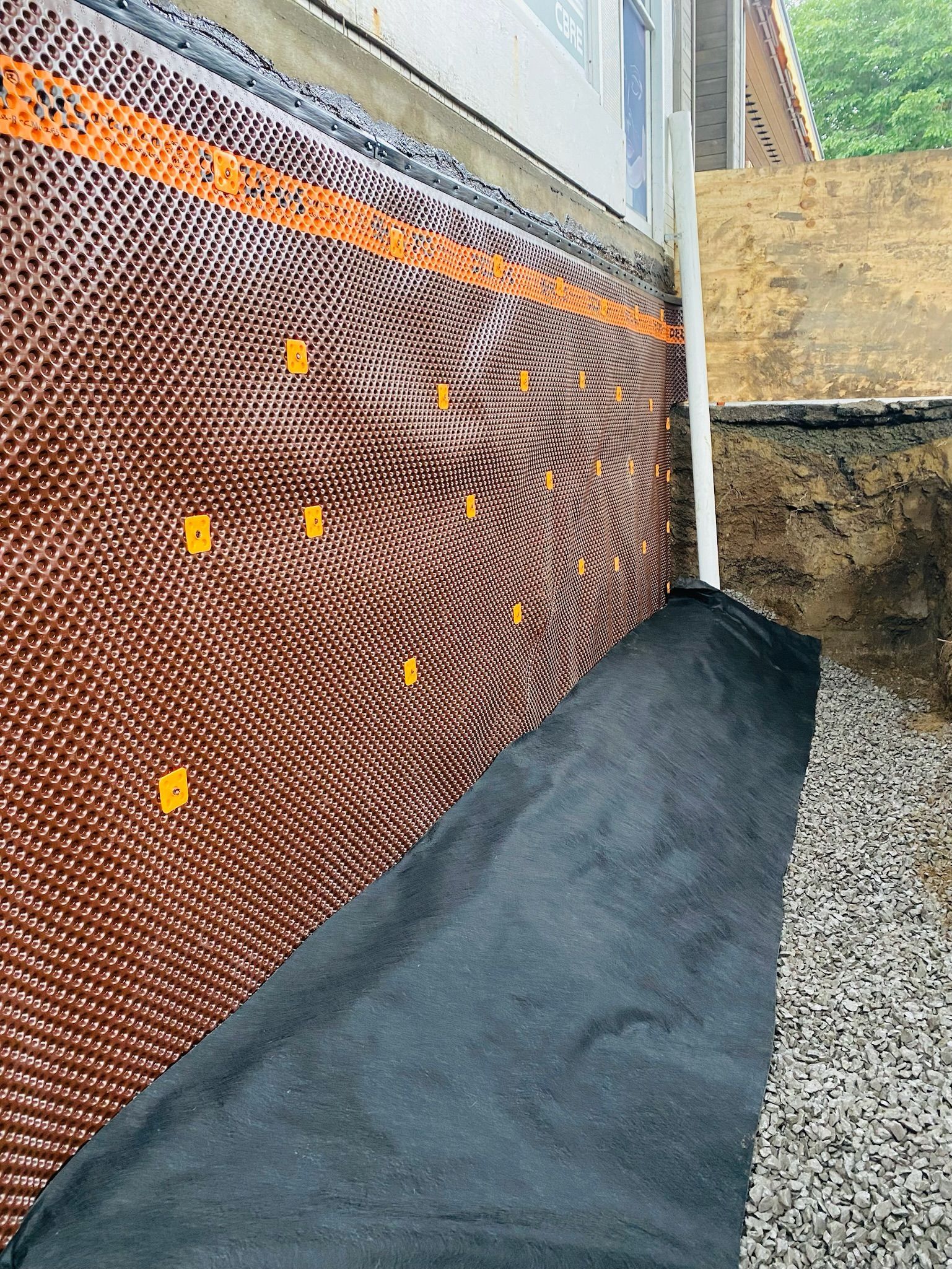 Un système de drainage est en cours d'installation sur le côté d'une maison.