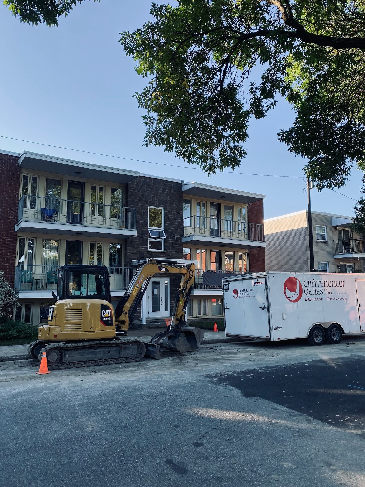 Un véhicule de construction est garé devant un bâtiment