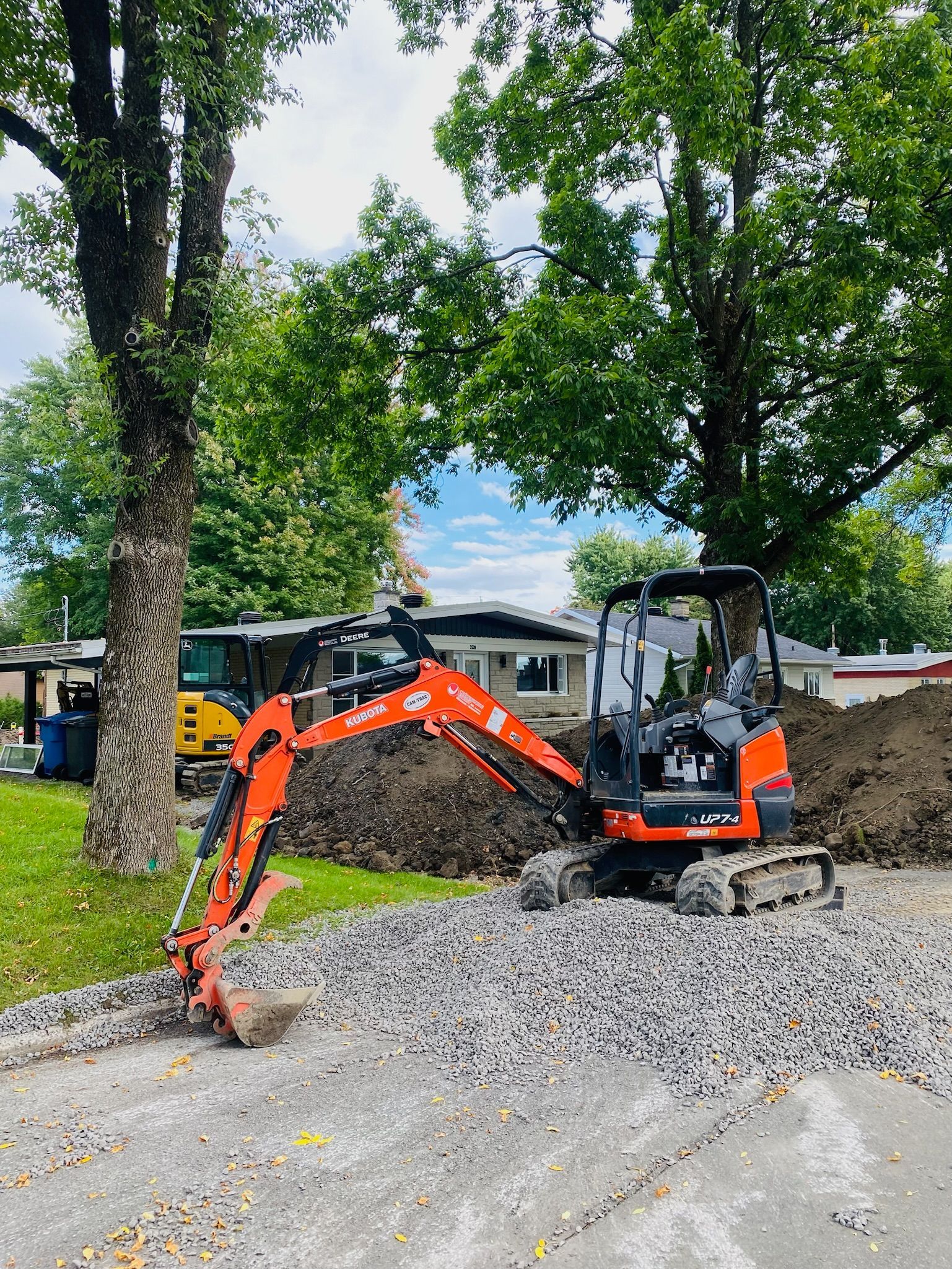Une petite excavatrice orange et noire creuse un trou dans le sol.