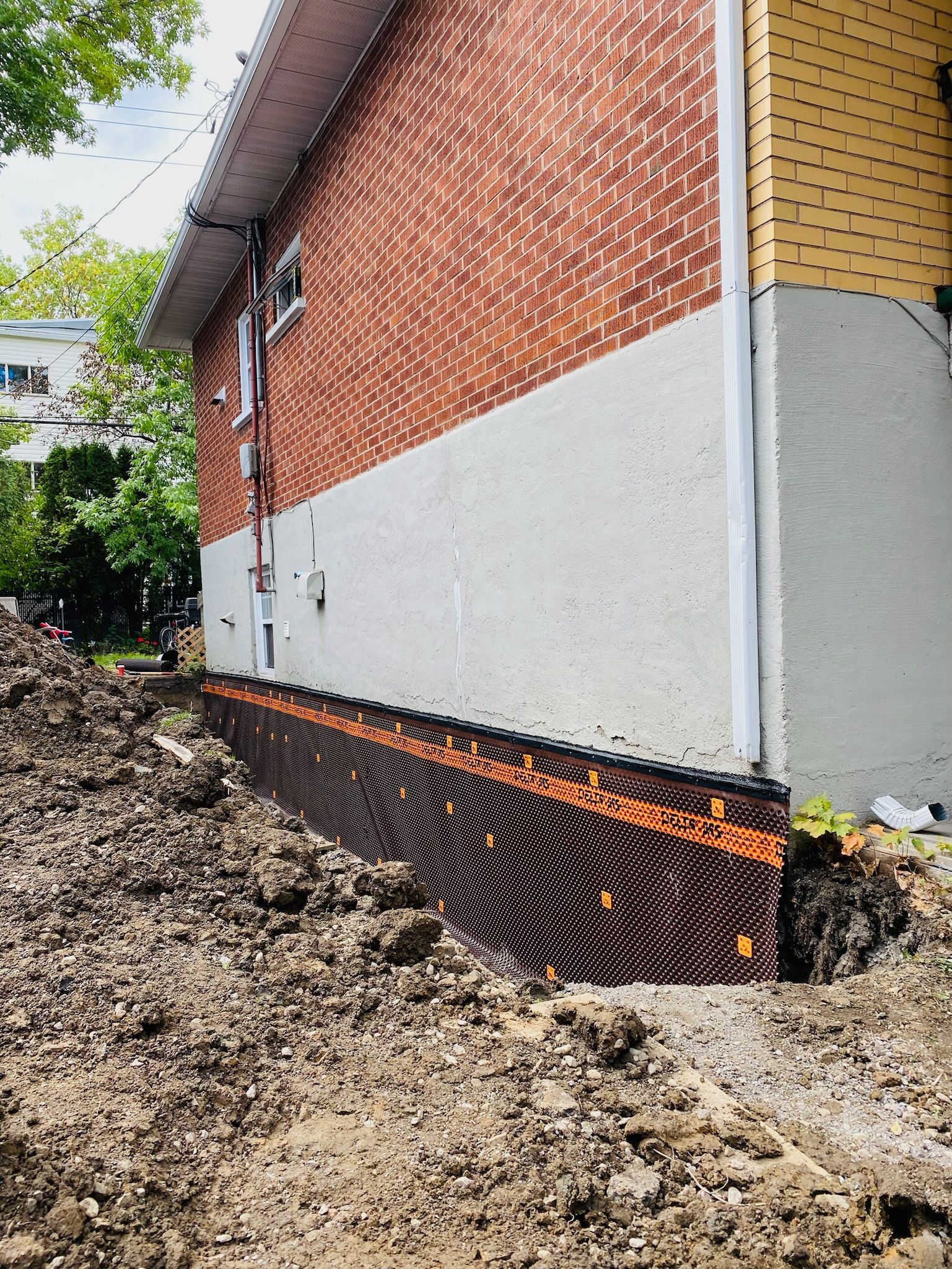 Une maison en briques avec beaucoup de terre devant.