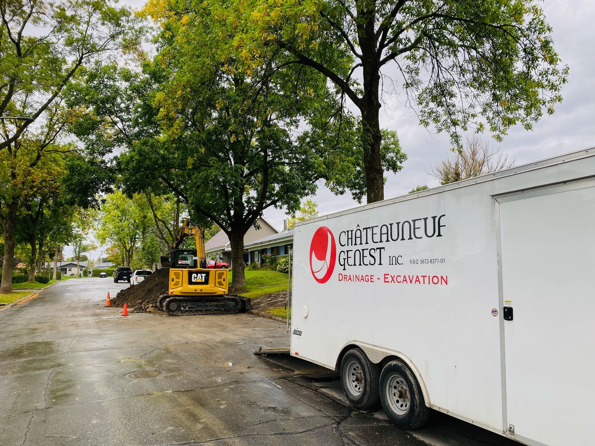Une remorque blanche est garée devant un chantier de construction.