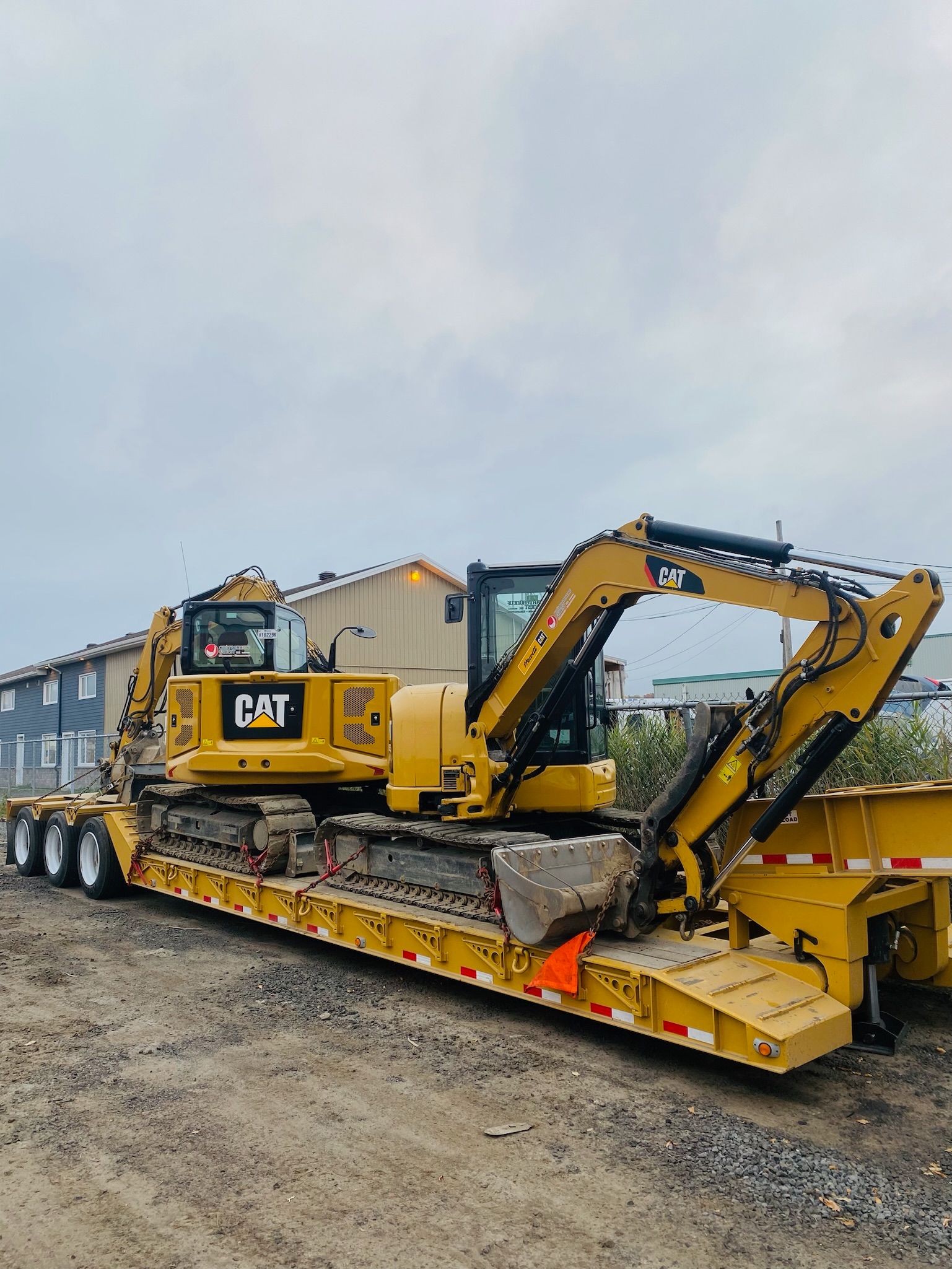 Une excavatrice jaune est assise sur une remorque jaune.
