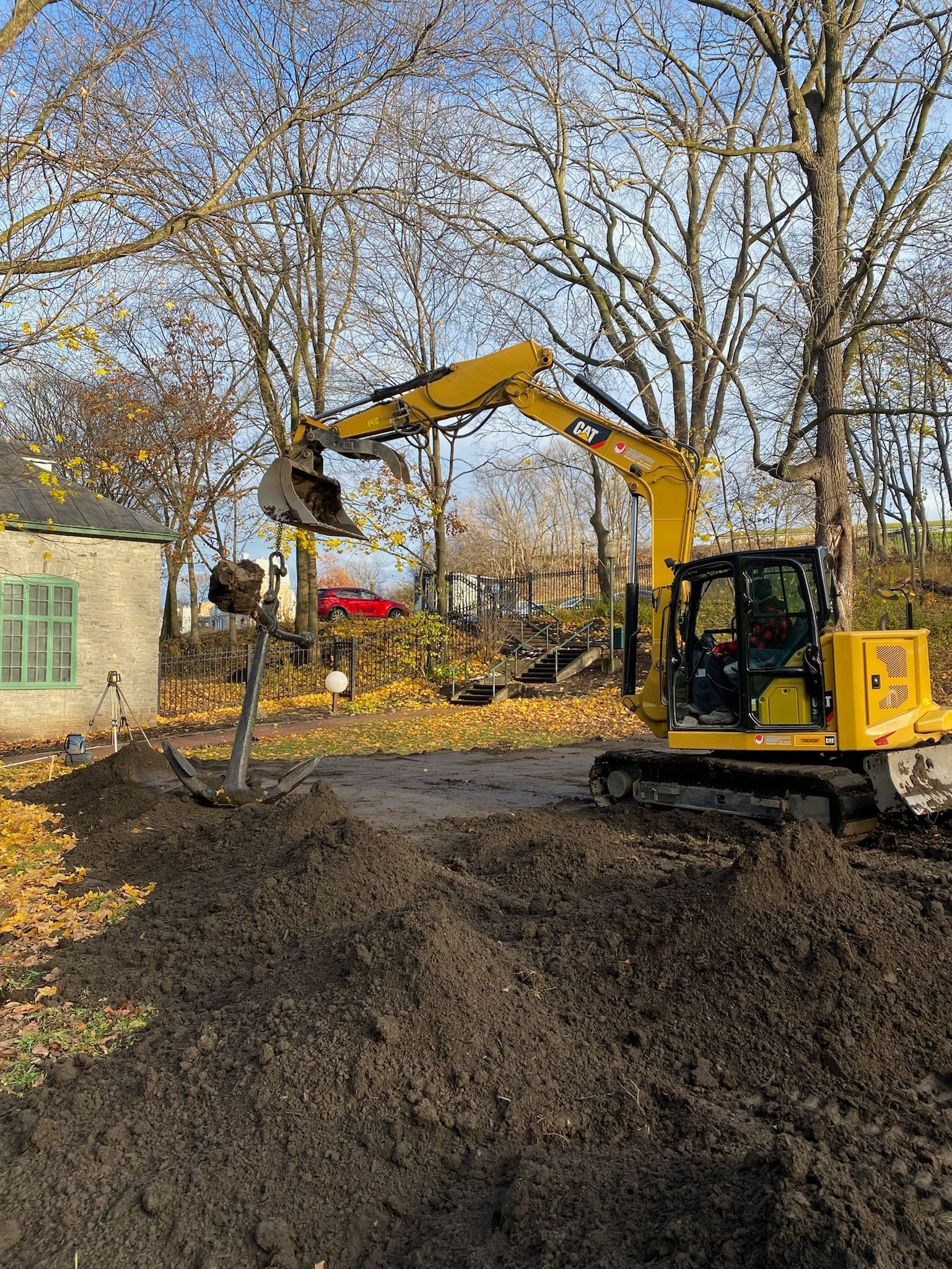 Une excavatrice jaune creuse un trou dans le sol.