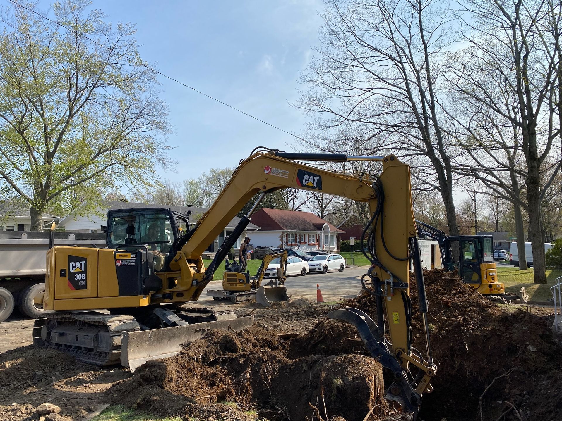 Une excavatrice à chat creuse un trou dans le sol.