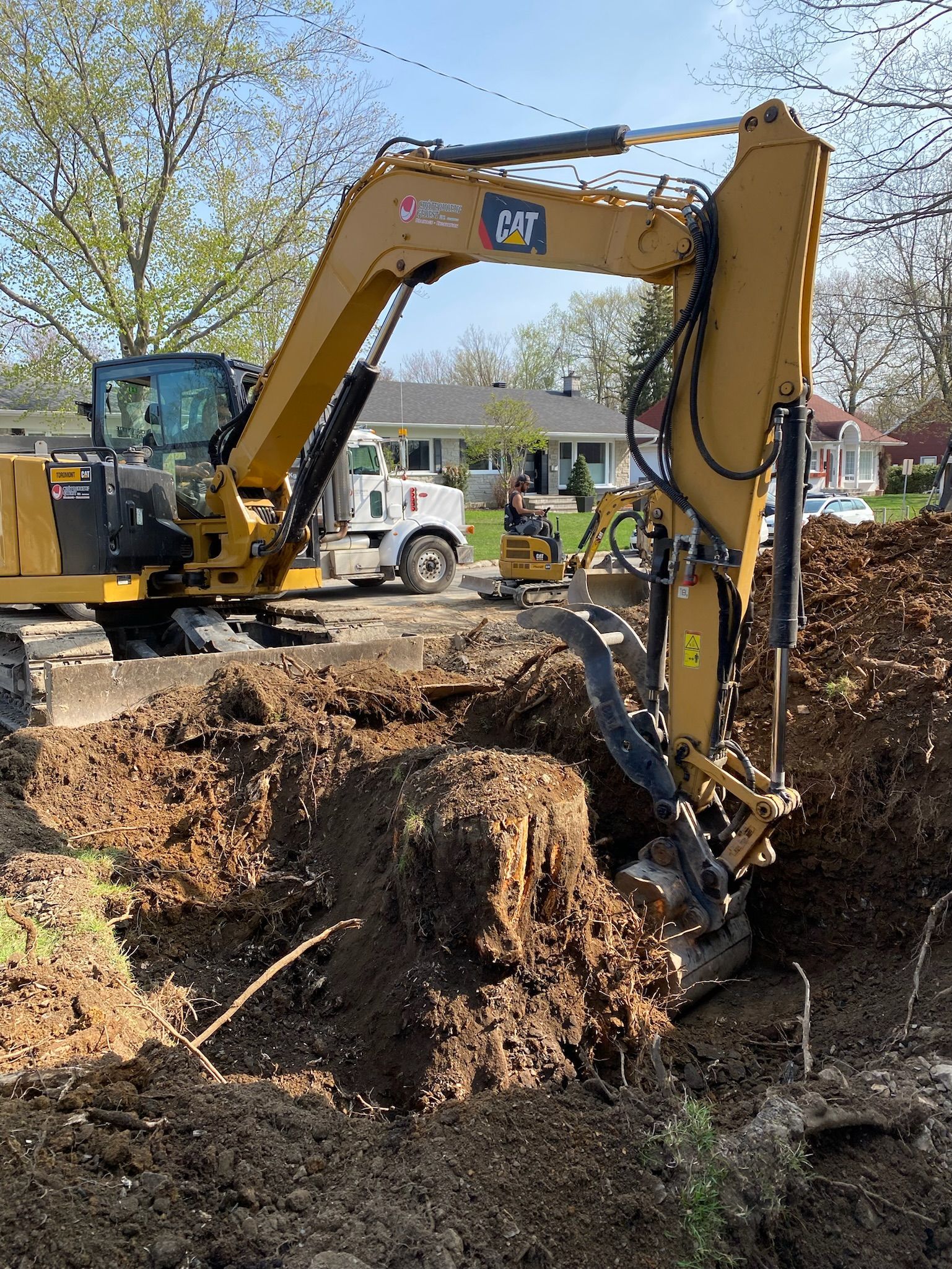 Une grande excavatrice jaune creuse un trou dans la terre.