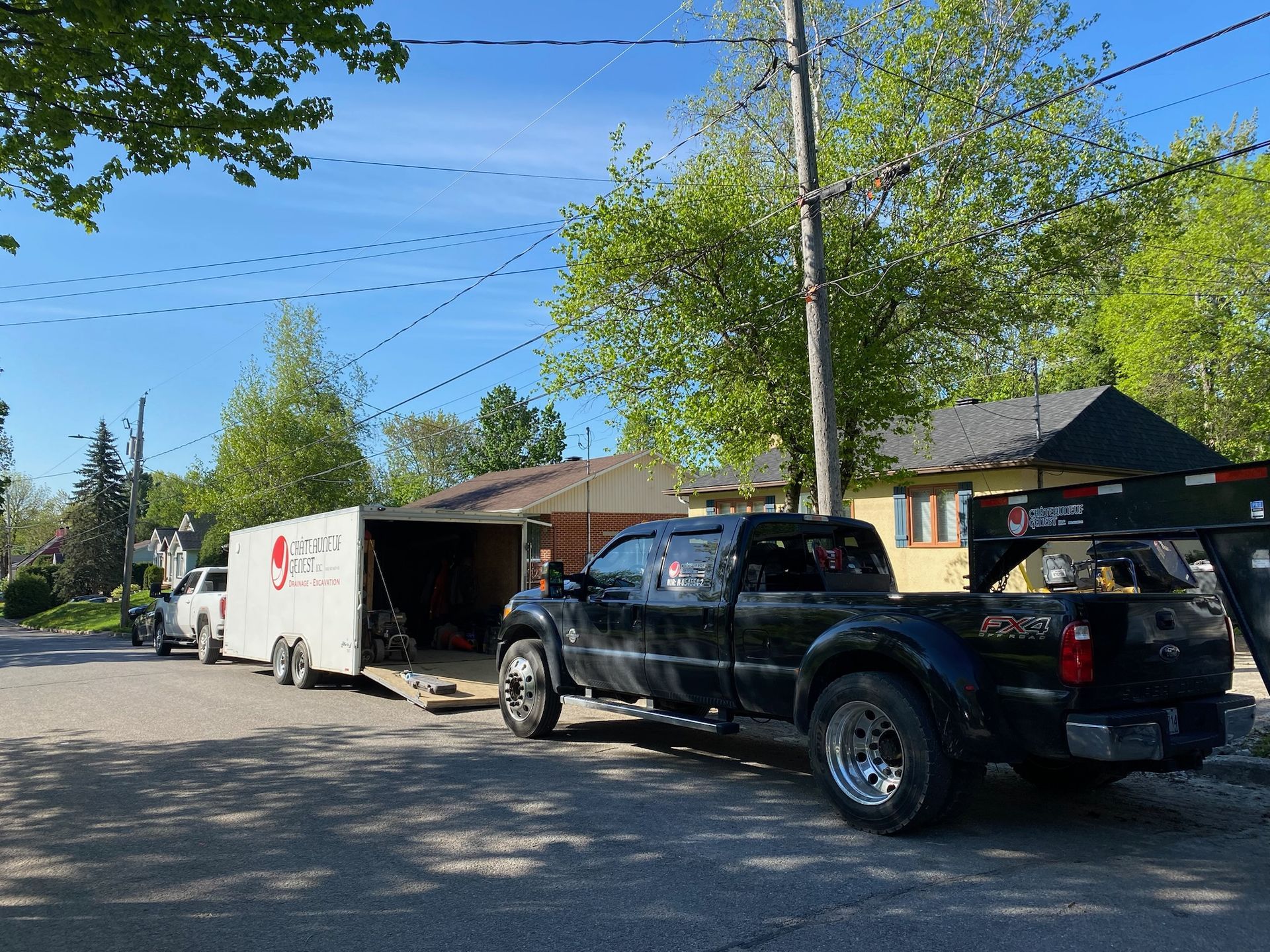 Un camion noir tire une remorque dans une rue.