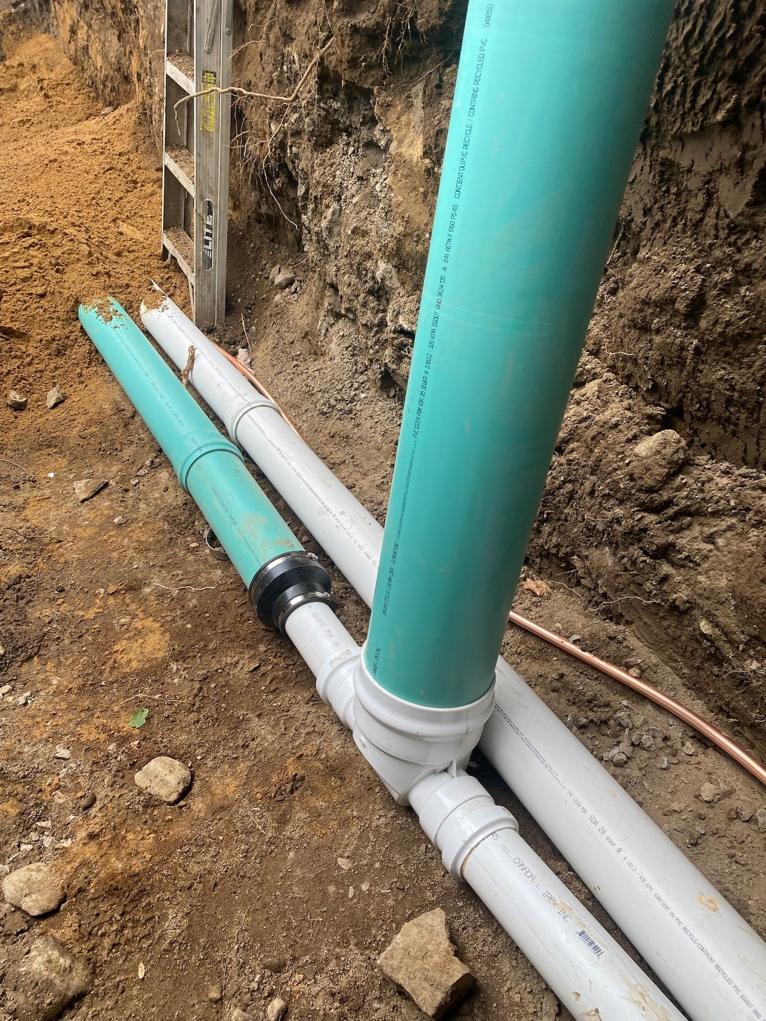 Une salle à manger avec une table et des chaises en bois et une cuisine en arrière-plan.