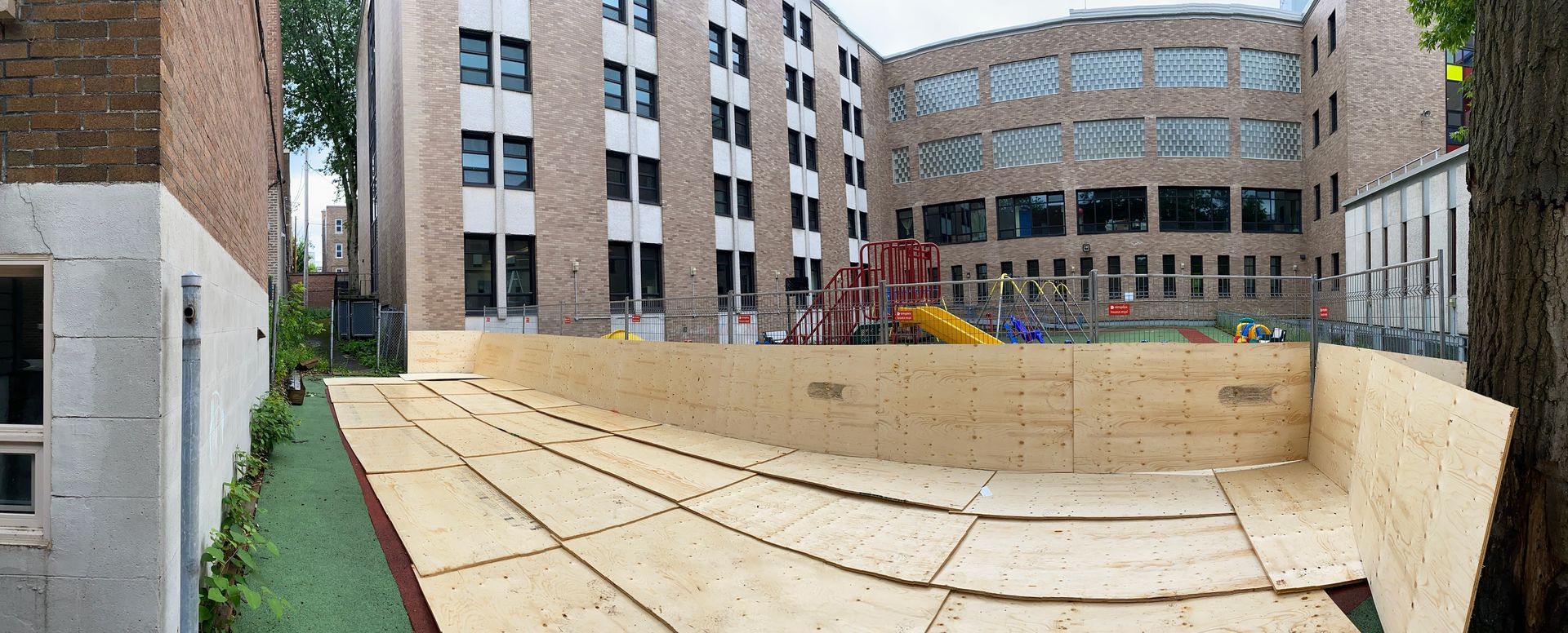 Une rampe en bois est en cours de construction devant un grand bâtiment.