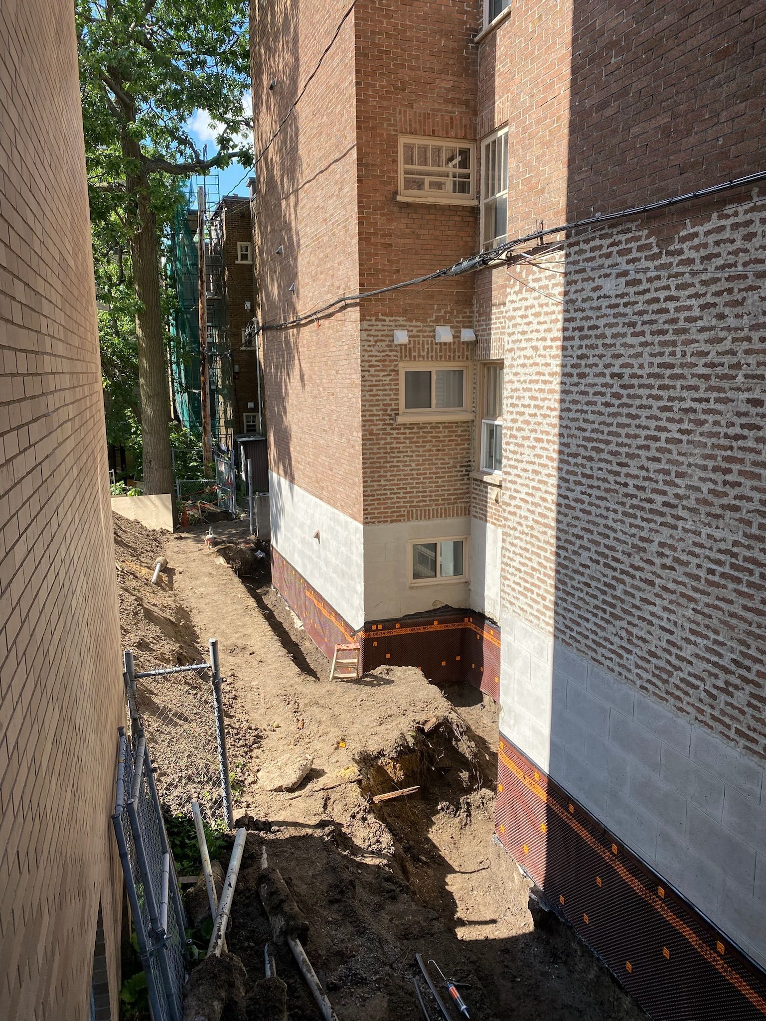 Un bâtiment en briques avec un trou dans le sol devant lui.