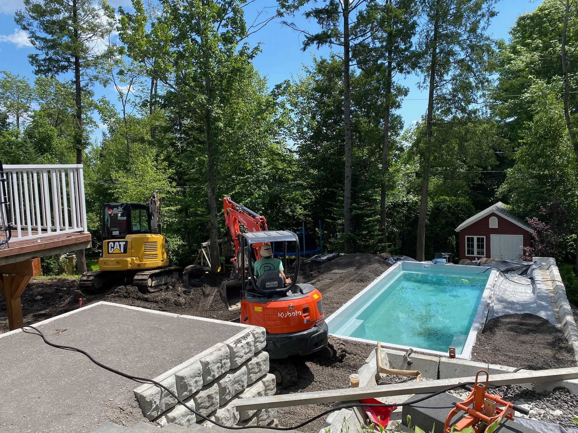 Une grande piscine est en cours de construction dans l'arrière-cour d'une maison.