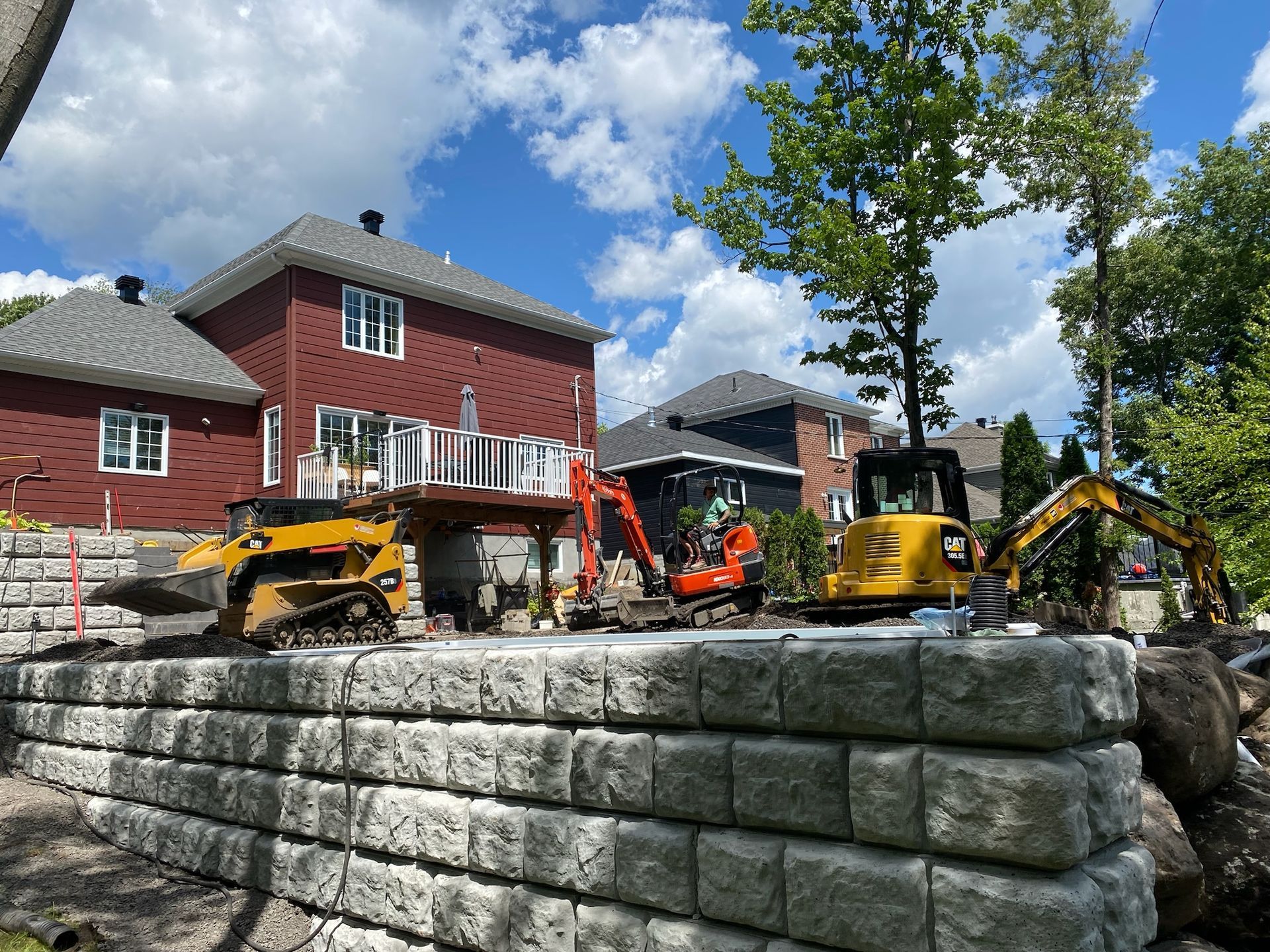 Un mur de briques est en train d'être construit devant une maison.