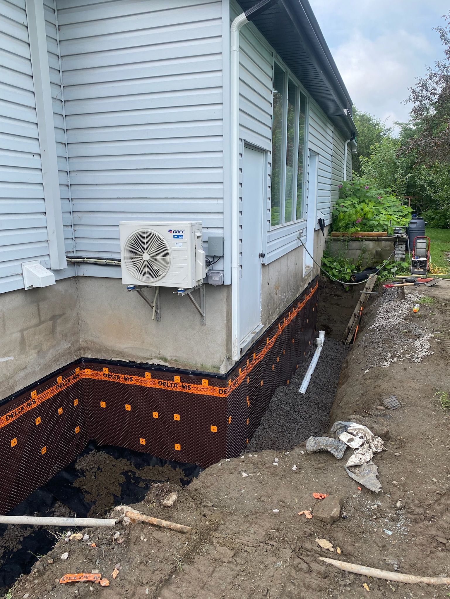 Une maison blanche avec un ventilateur sur le côté.