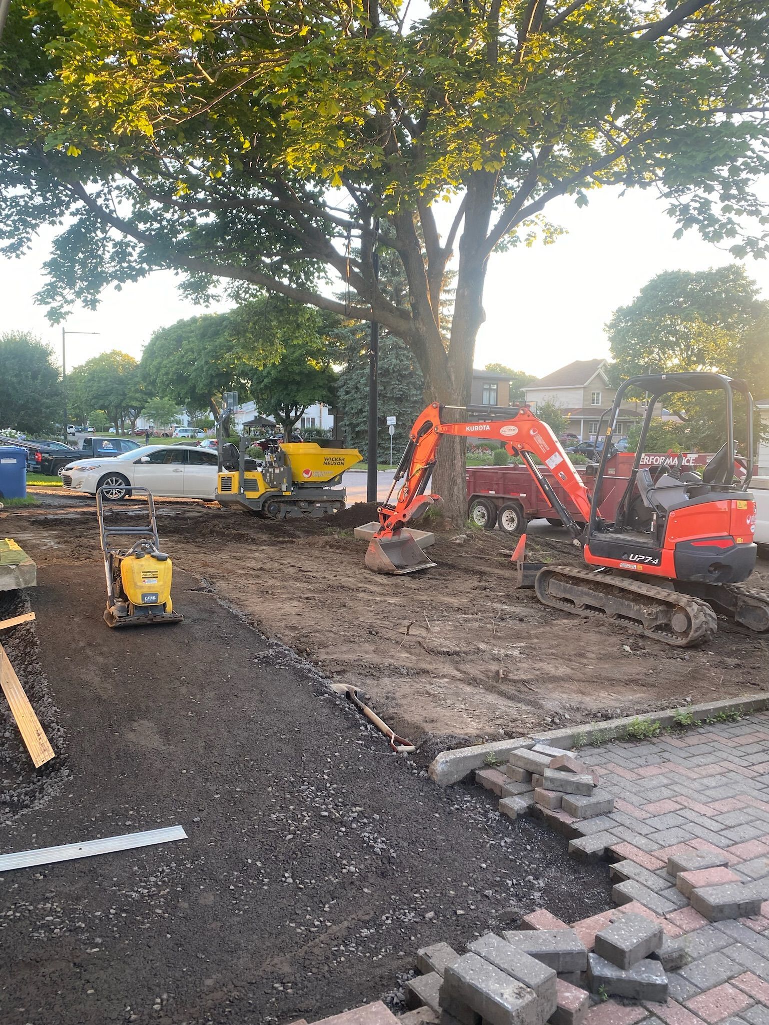 Un chantier avec beaucoup de machines et un arbre en arrière-plan.