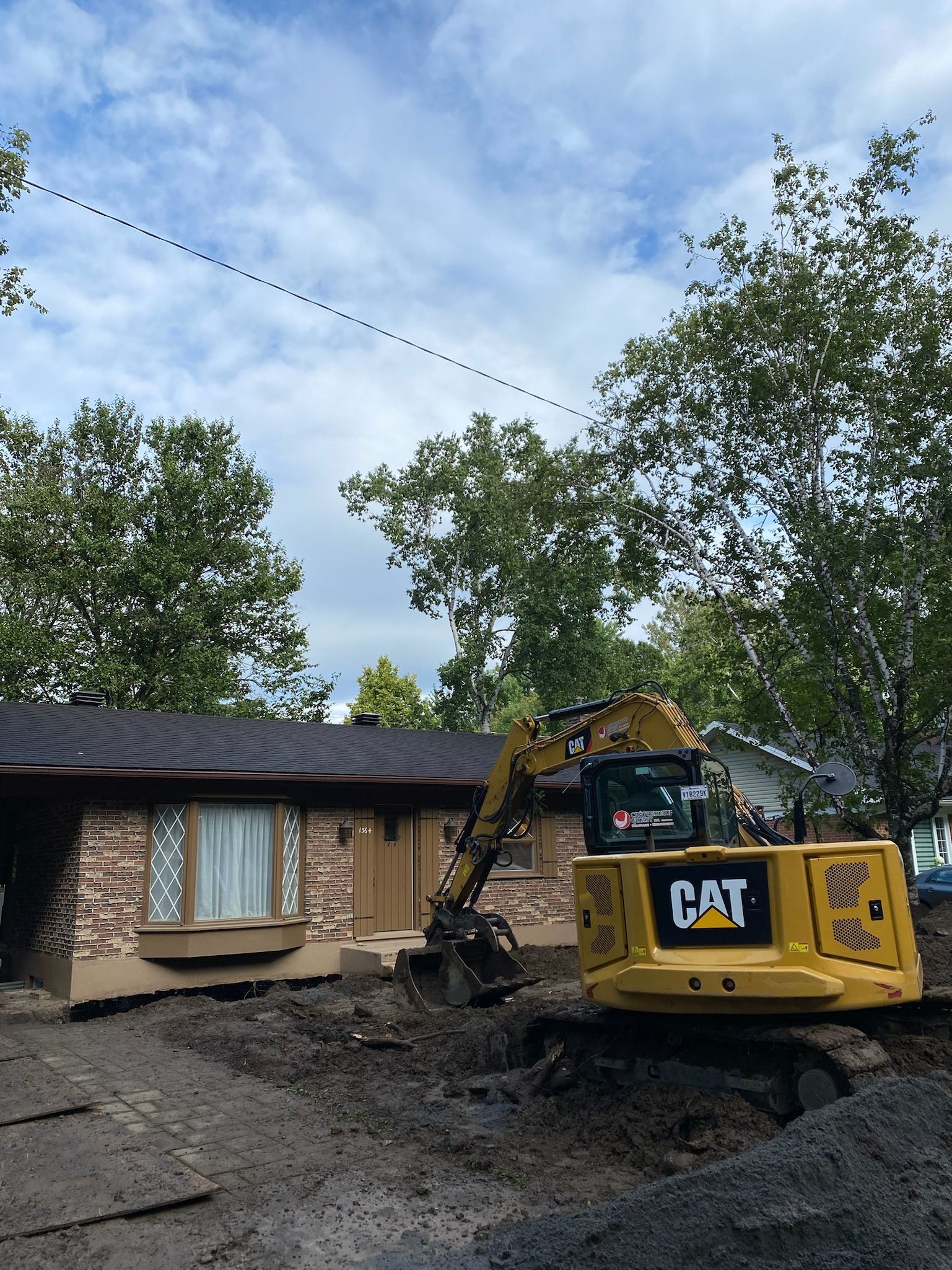 Une excavatrice à chat est utilisée pour démolir une maison