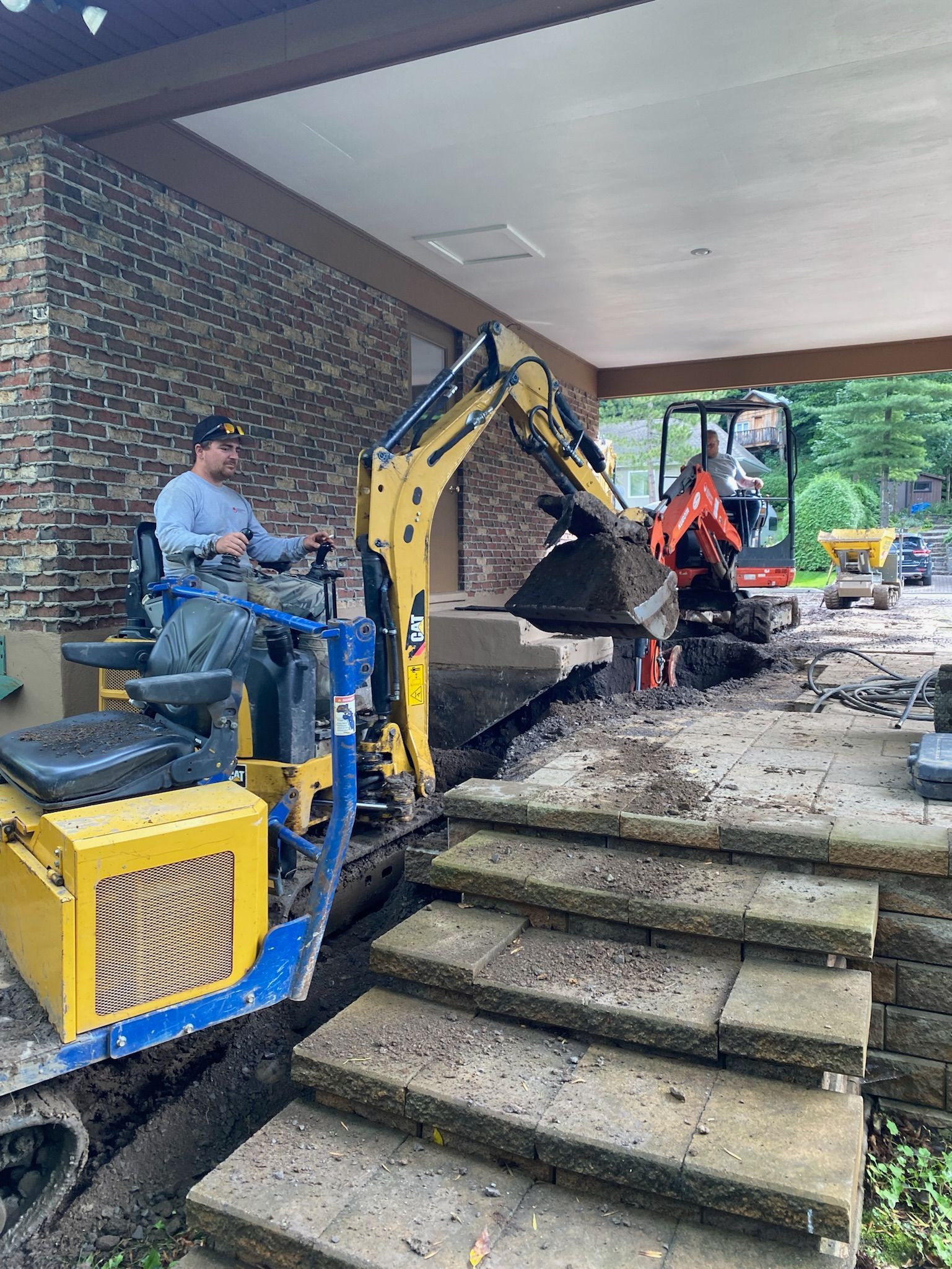 Un homme conduit une excavatrice à côté d'un escalier.