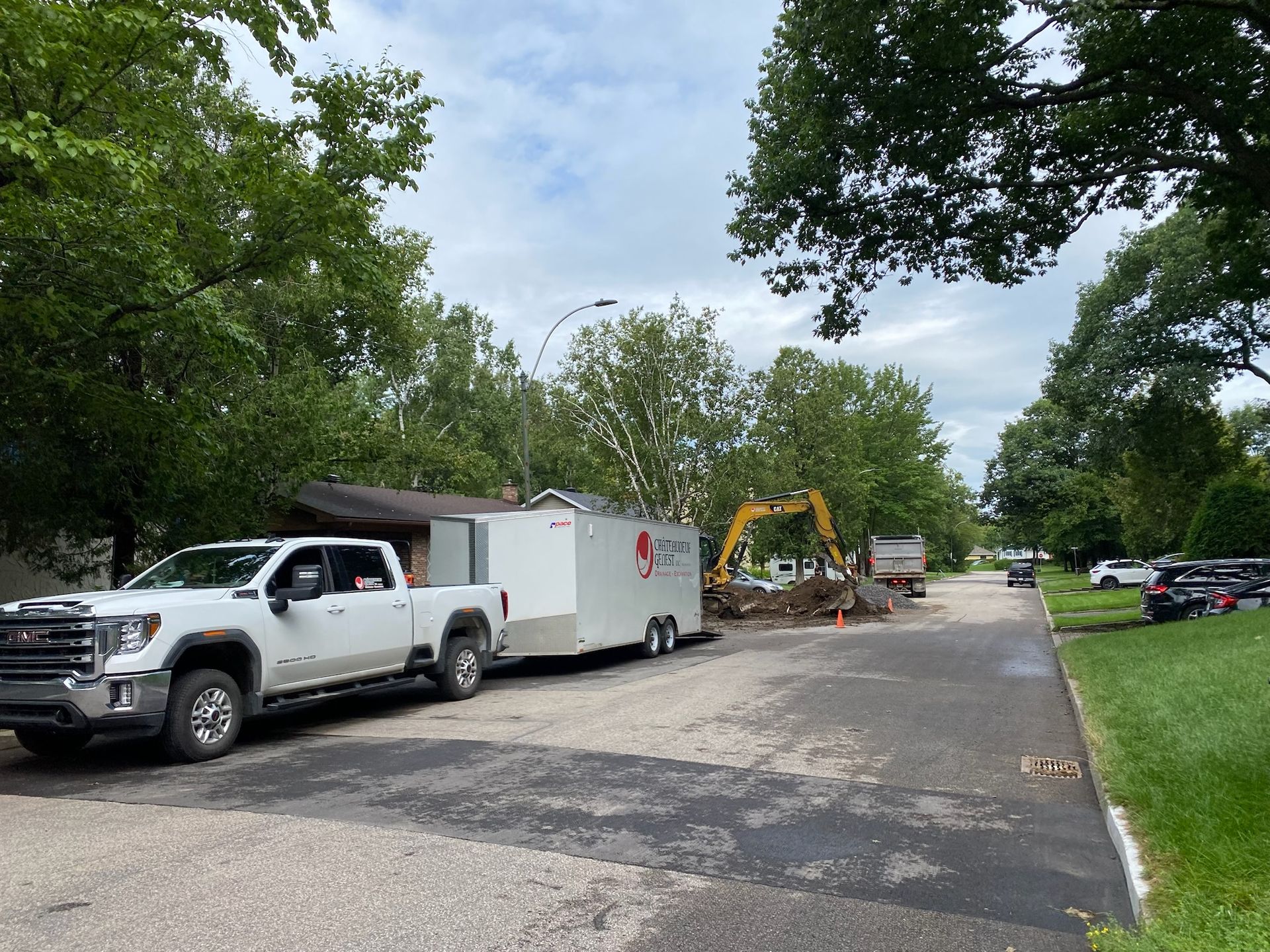 Un camion blanc est garé sur le bord de la route à côté d'une remorque.