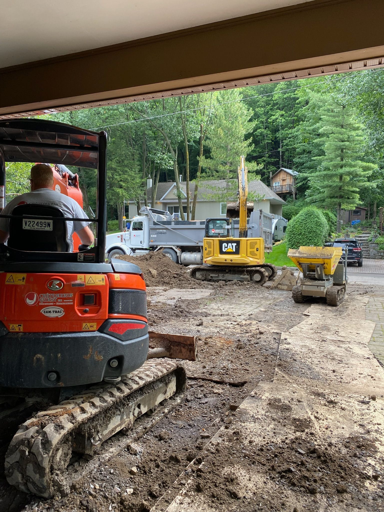 Un homme conduit un bulldozer sur un chemin de terre.