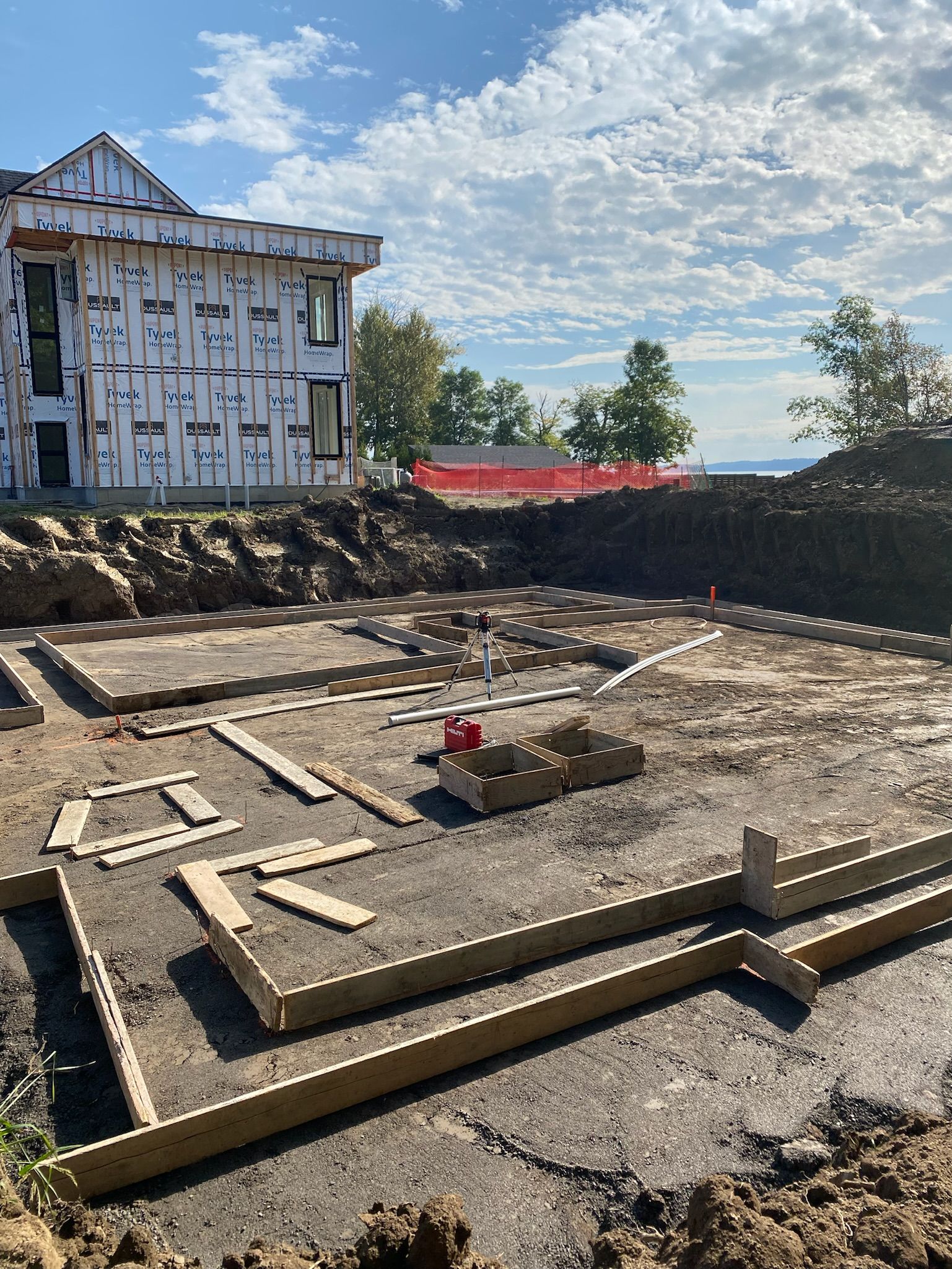 Une maison est en construction au milieu d'un champ de terre.