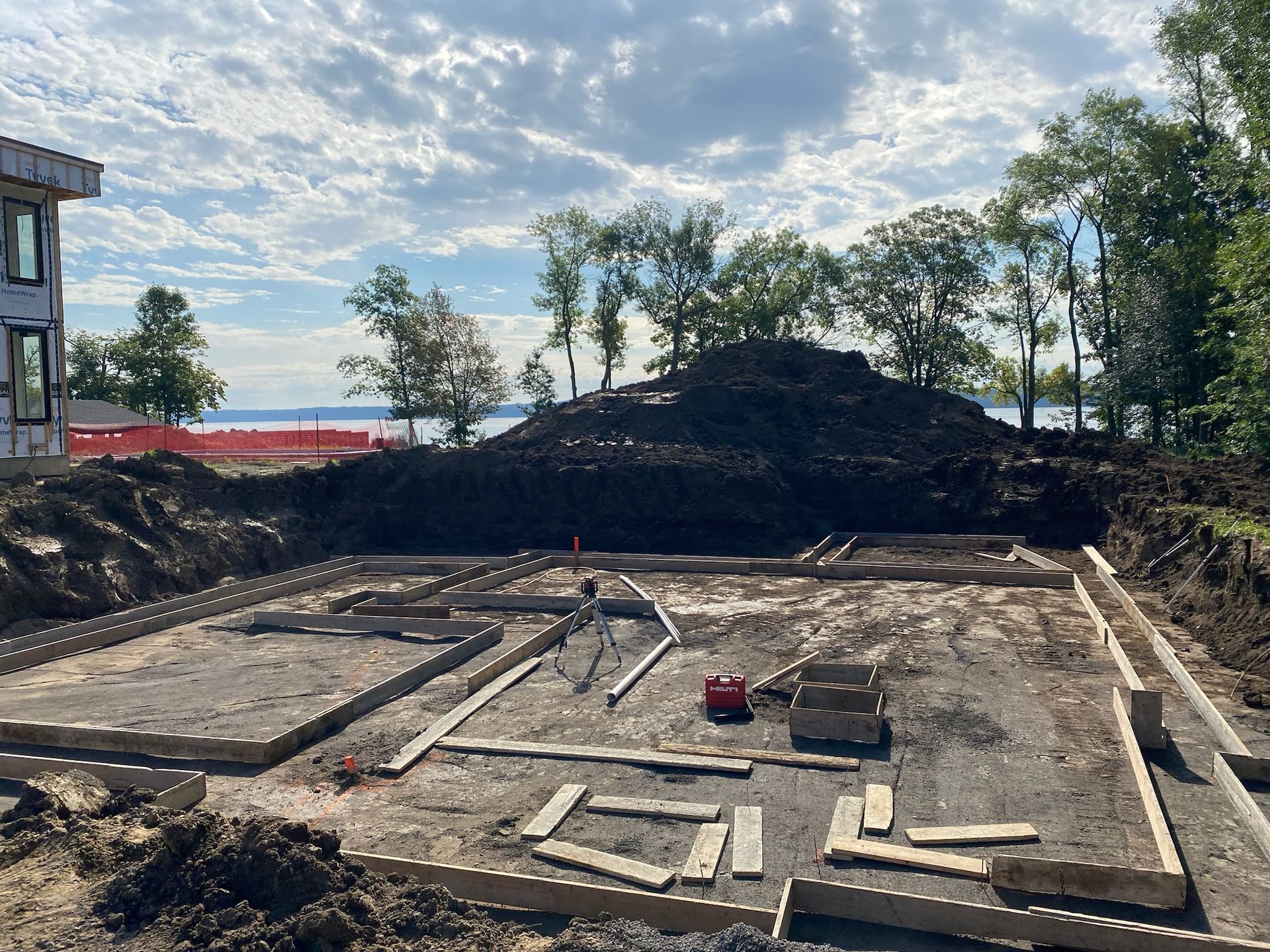 Un chantier de construction avec un gros tas de terre en arrière-plan.