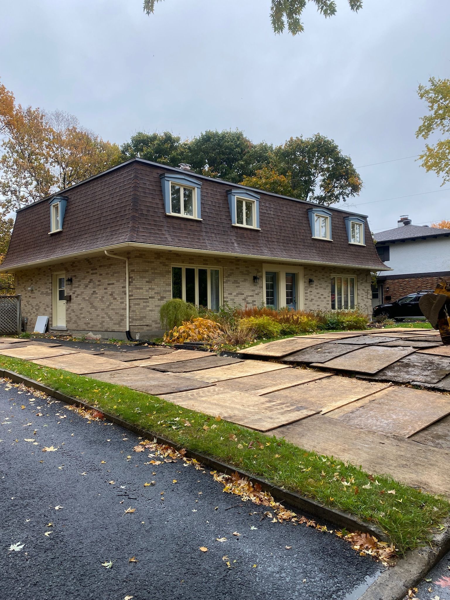 Une grande maison en briques avec un toit qui est en train d'être démoli.