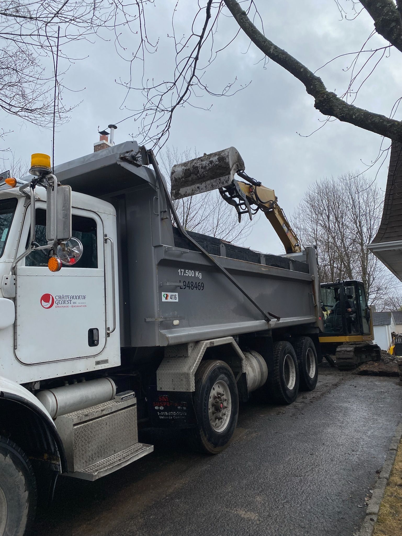 Un camion à benne basculante est chargé de terre par un bulldozer.