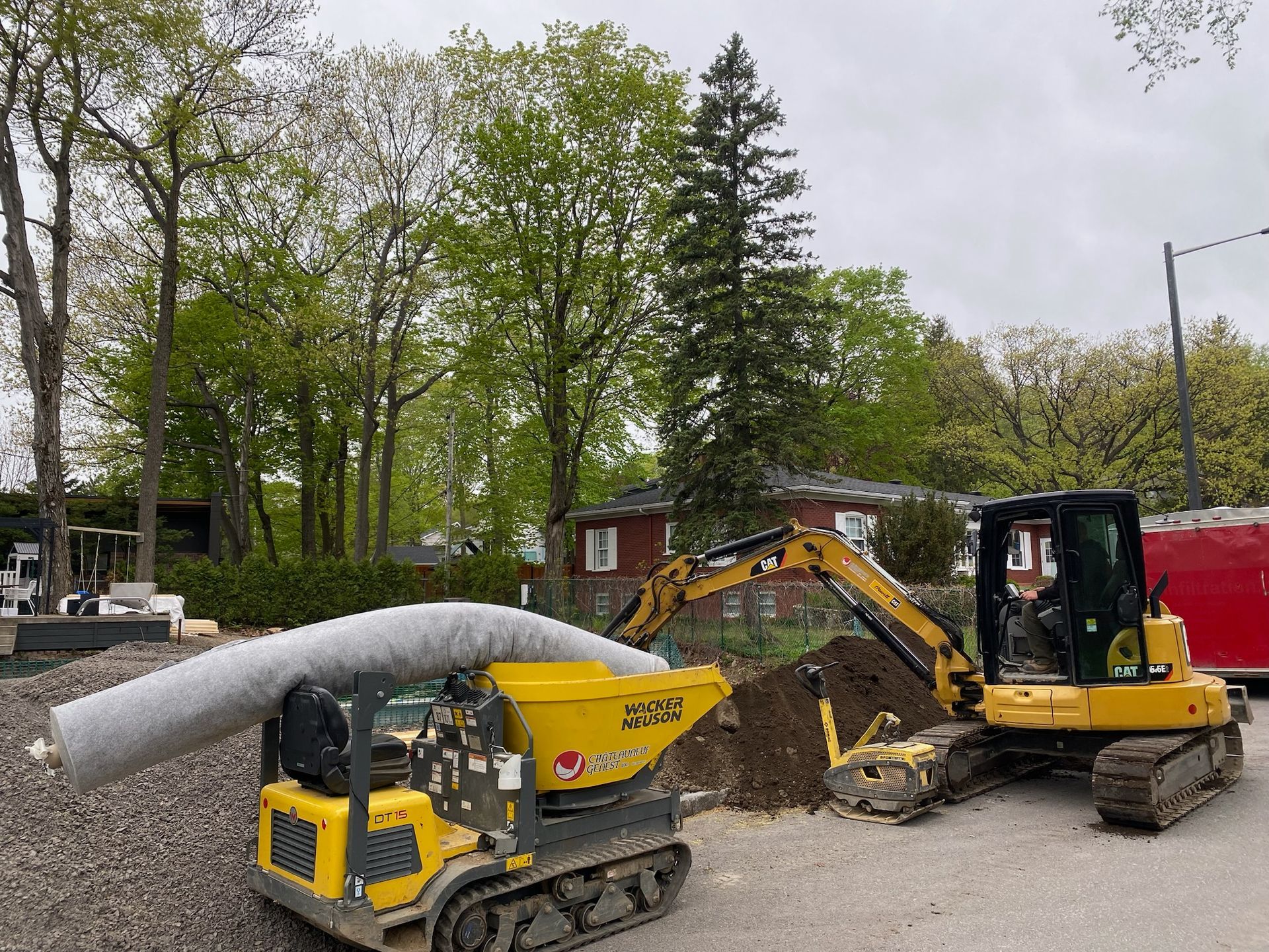 Une excavatrice jaune charge de la terre dans une benne à ordures.