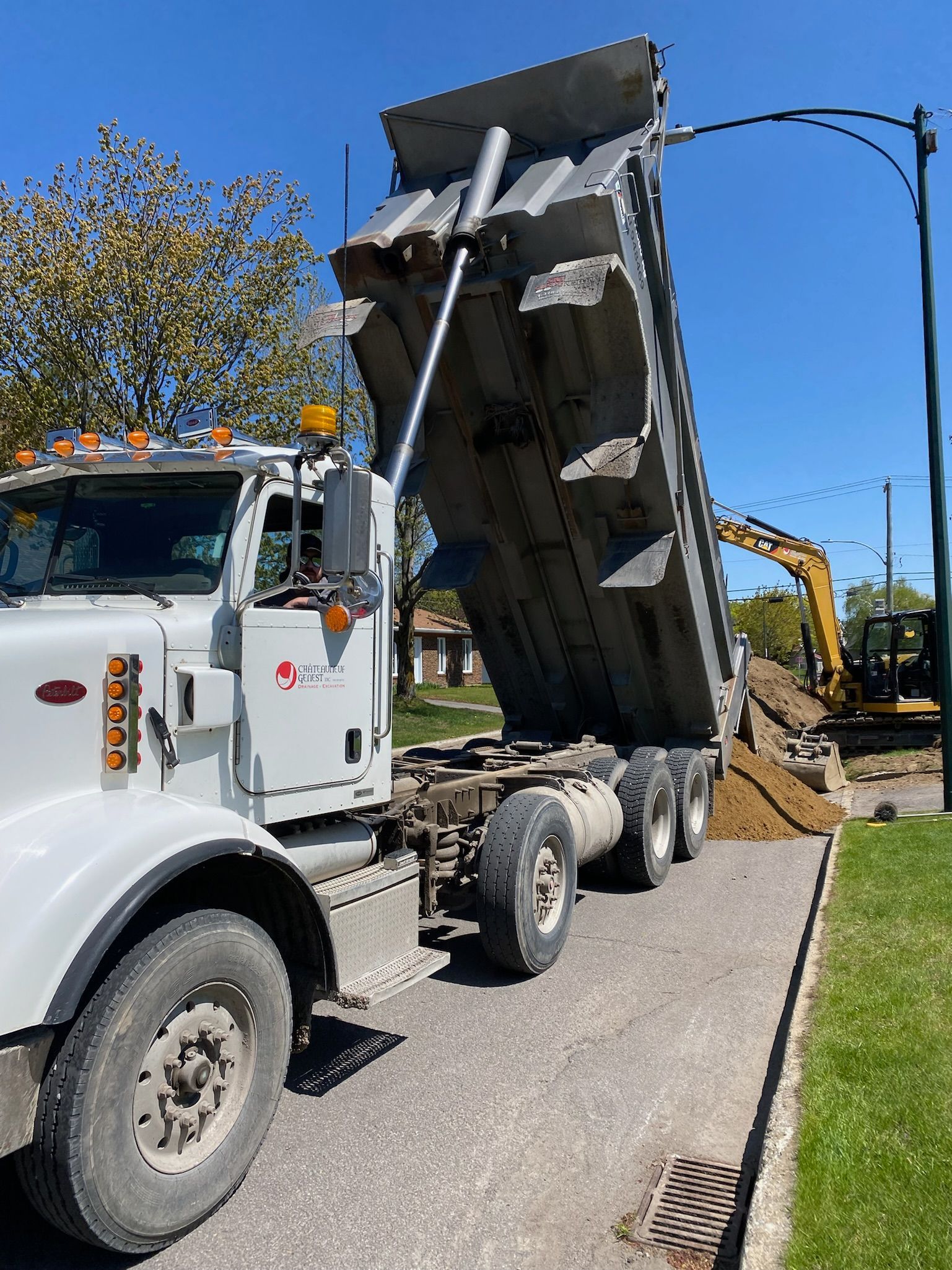 Un camion à benne basculante est stationné sur le bord de la route.