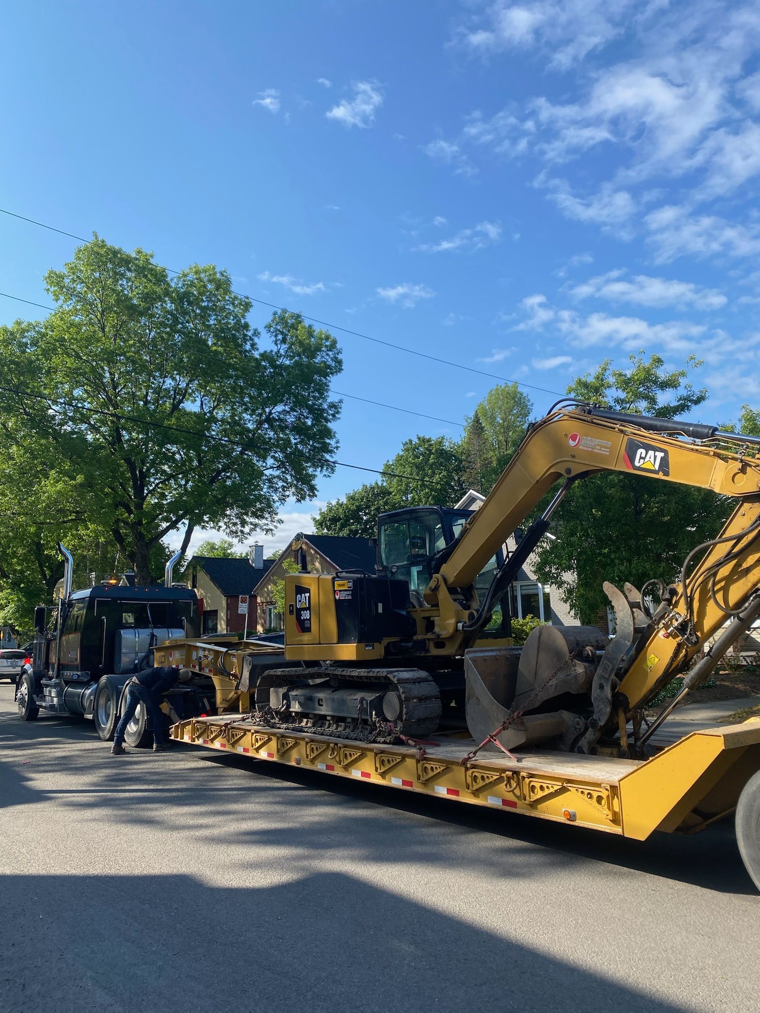 Une grande excavatrice jaune est assise sur une remorque à plateau.
