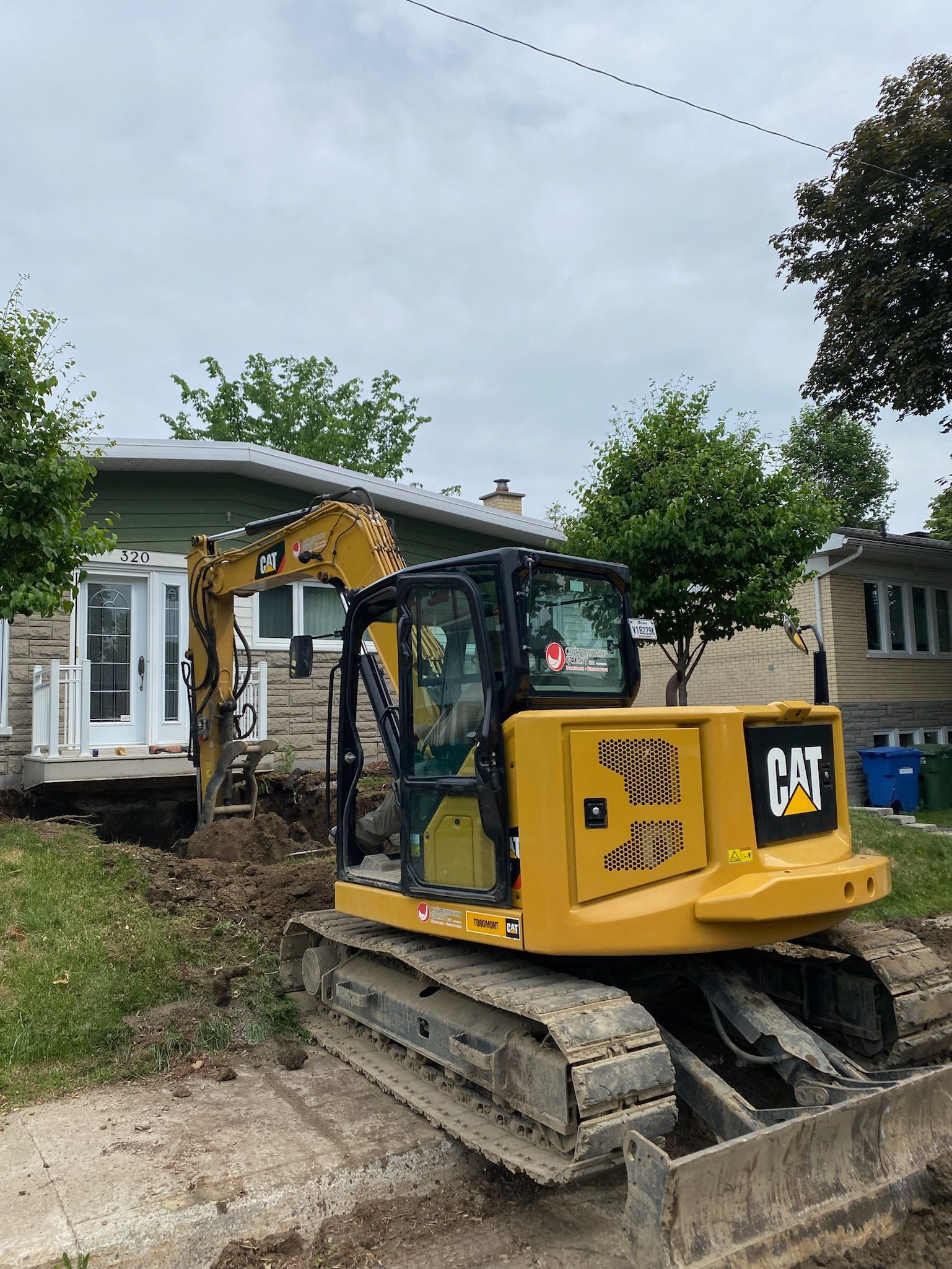 Un bulldozer jaune est assis devant une maison.