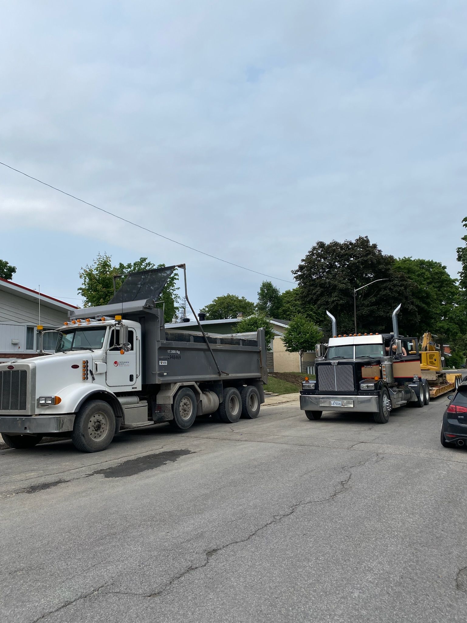 Deux camions à benne basculante sont garés sur le bord de la route.