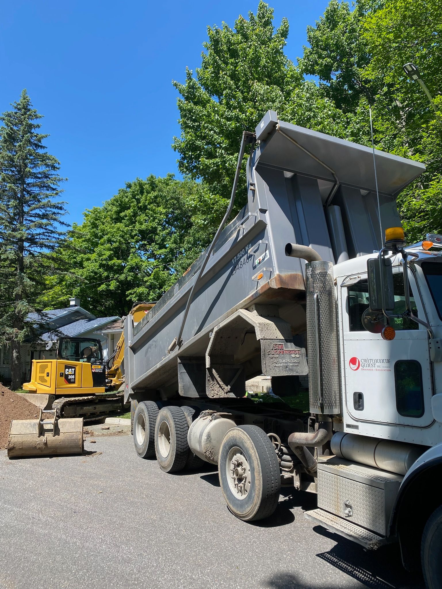 Un camion à benne basculante est garé sur le bord de la route.