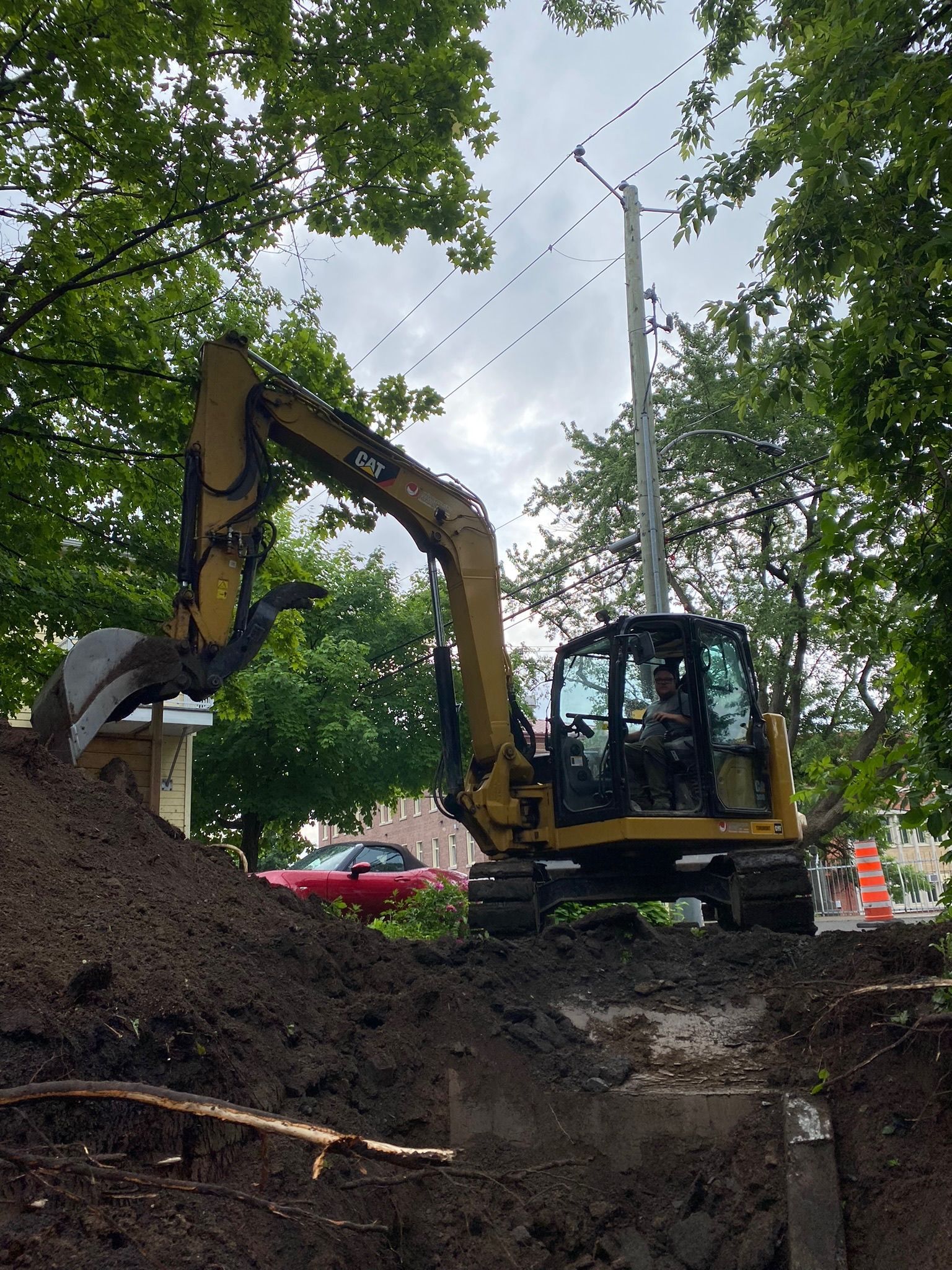 Une excavatrice jaune creuse un trou dans le sol.