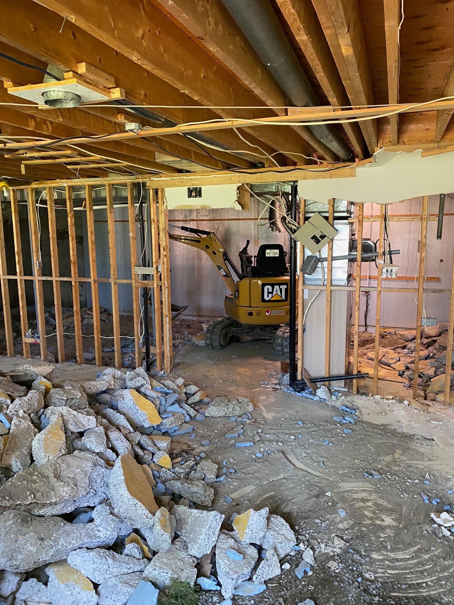 Une excavatrice à chat est utilisée pour démolir une maison.