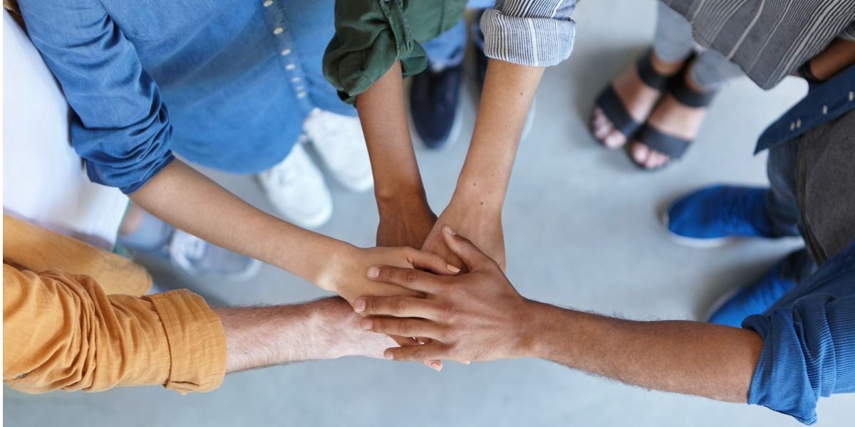 Mani unite in cerchio, a simboleggiare il lavoro di squadra e la collaborazione.