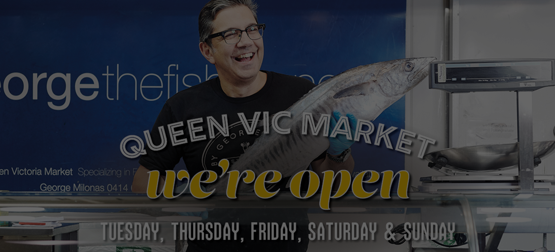 A man is holding a large fish in front of a sign that says queen vic market