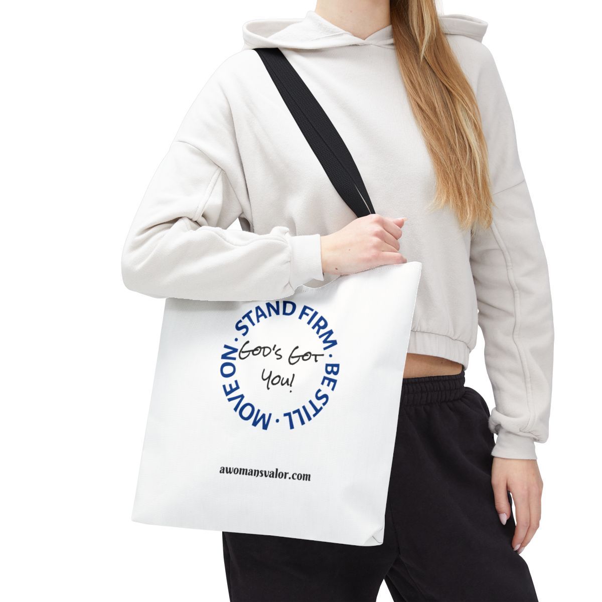 Woman holding a white tote bag with blue text that says