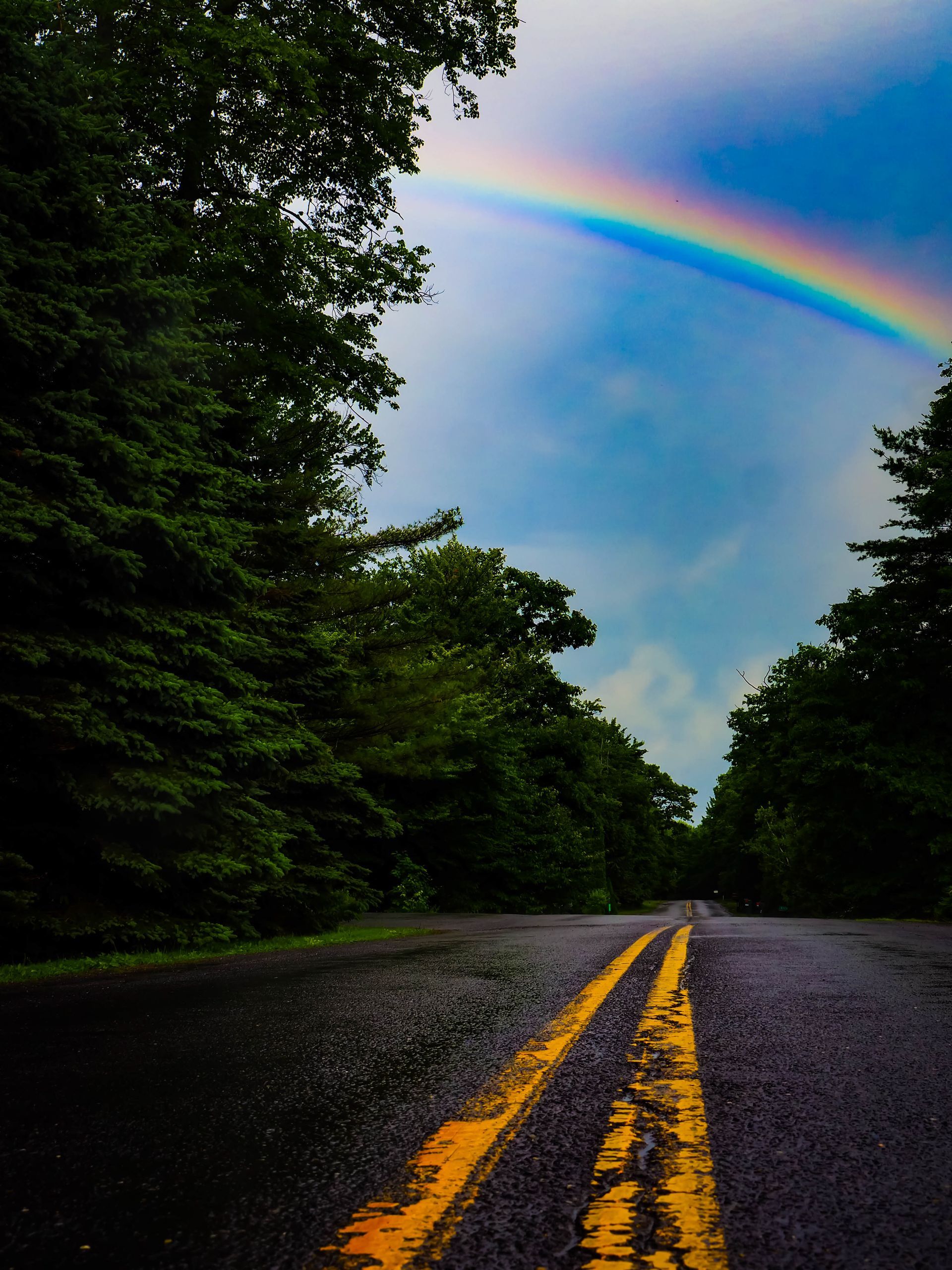 A road with a rainbow in the sky above it
