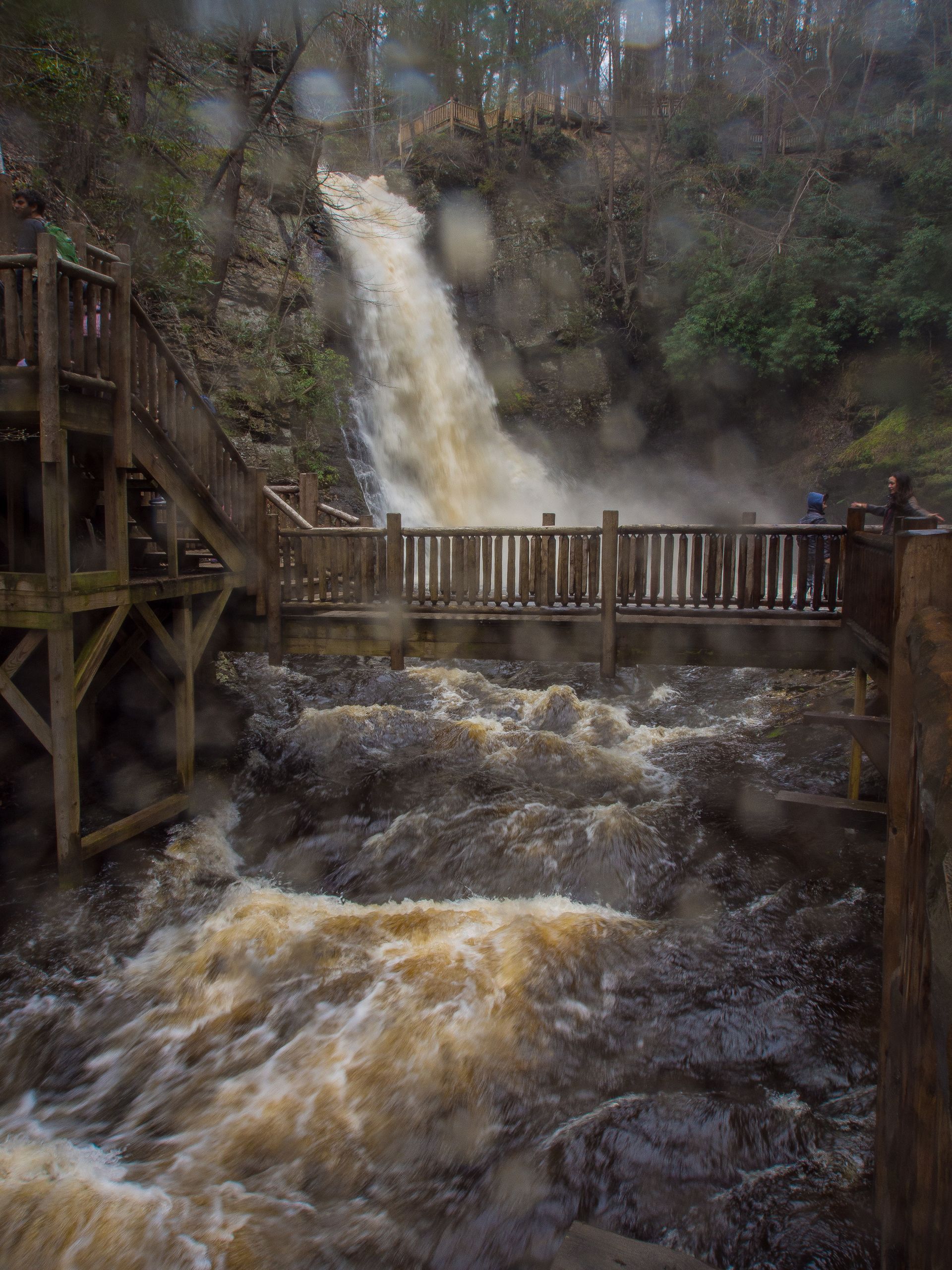 A bridge over a river with a waterfall in the background