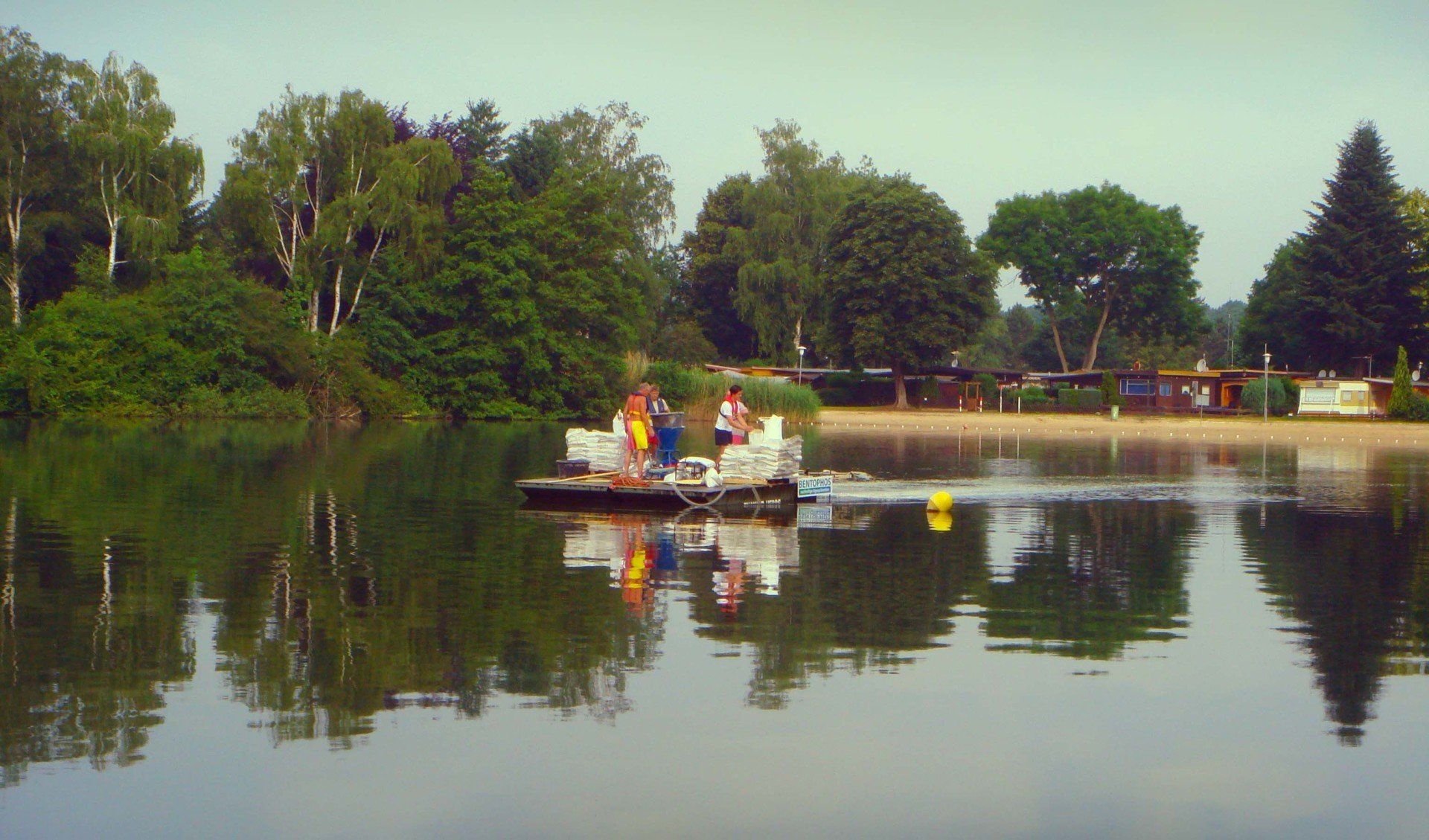 A boat is floating on a lake with trees in the background