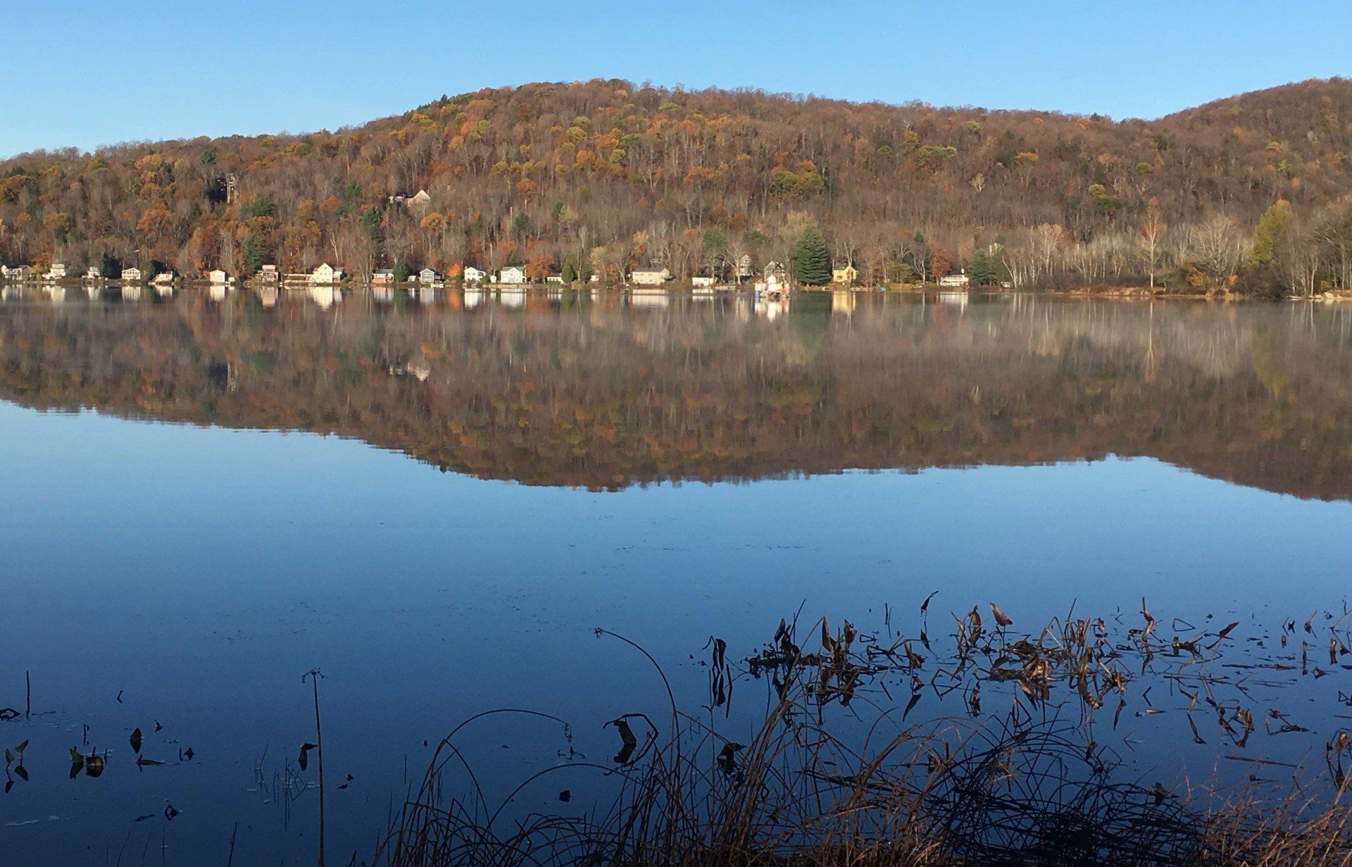 A lake with mountains in the background and trees reflected in the water