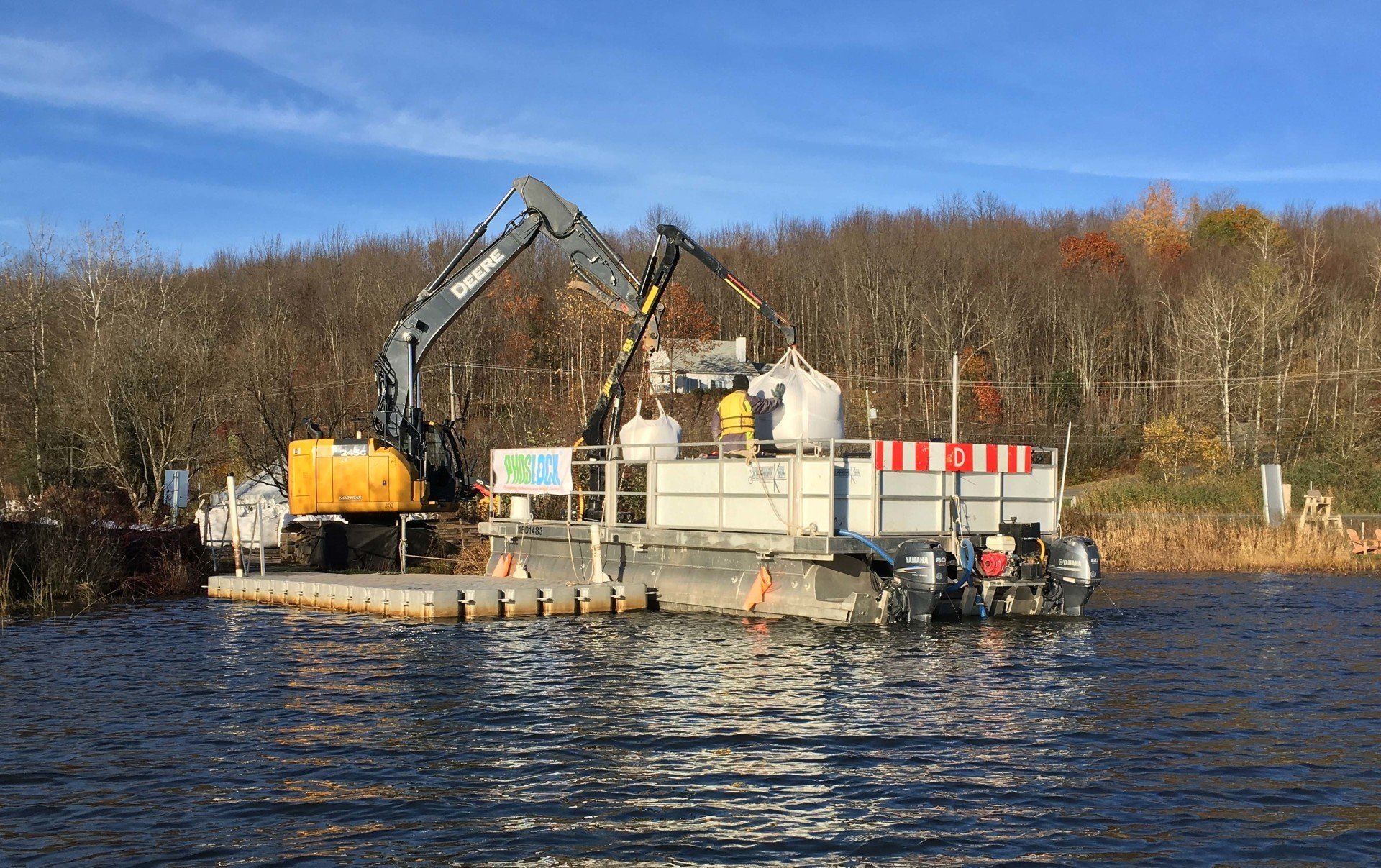 A large crane is sitting on top of a boat in the middle of a lake.
