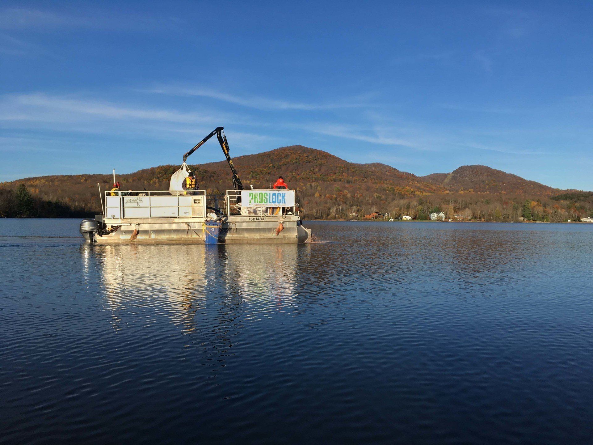 A boat is floating on top of a lake with mountains in the background.